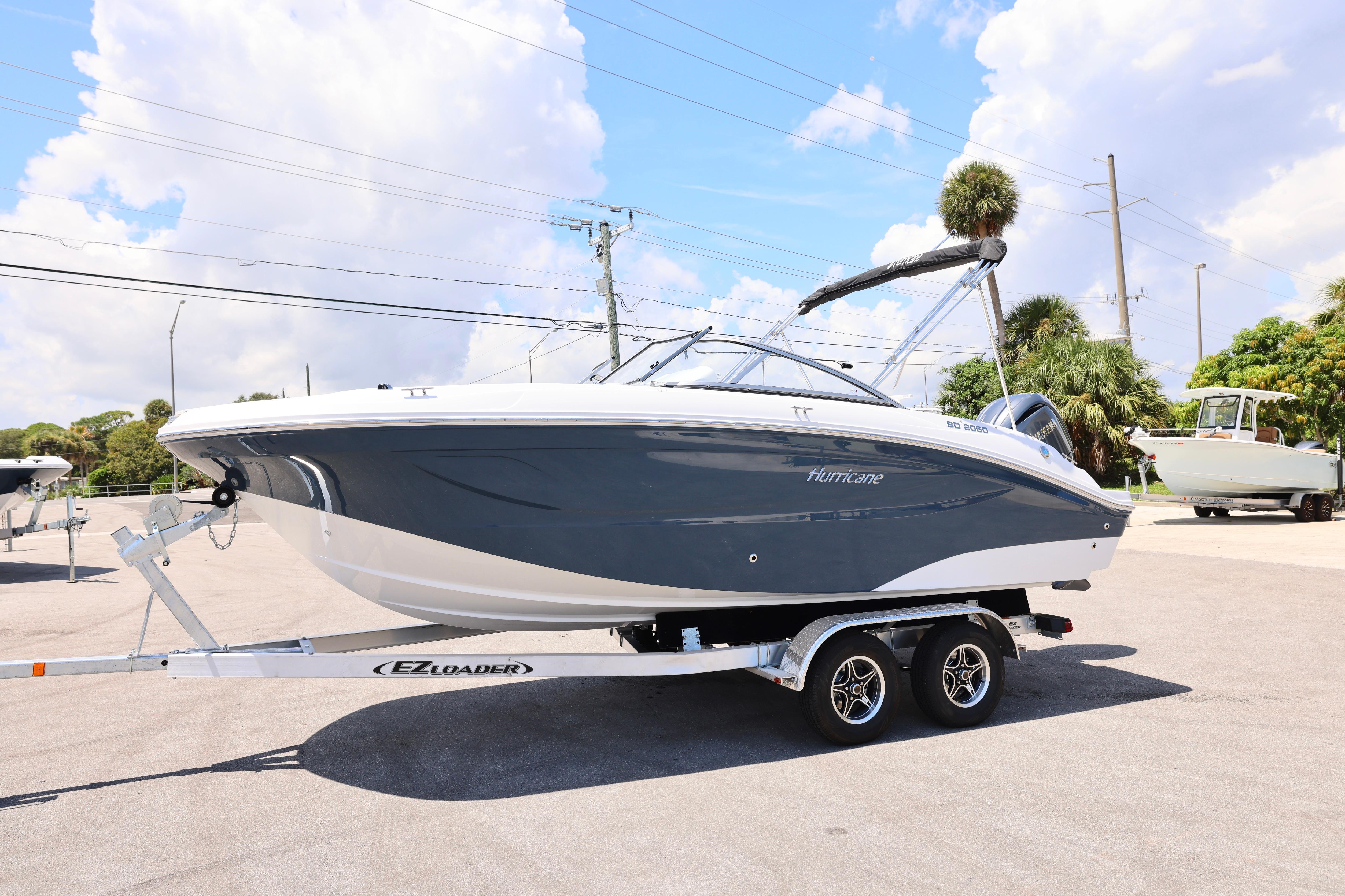 2026 Hurricane SunDeck 2050 OB boat on trailer under a sunny sky.