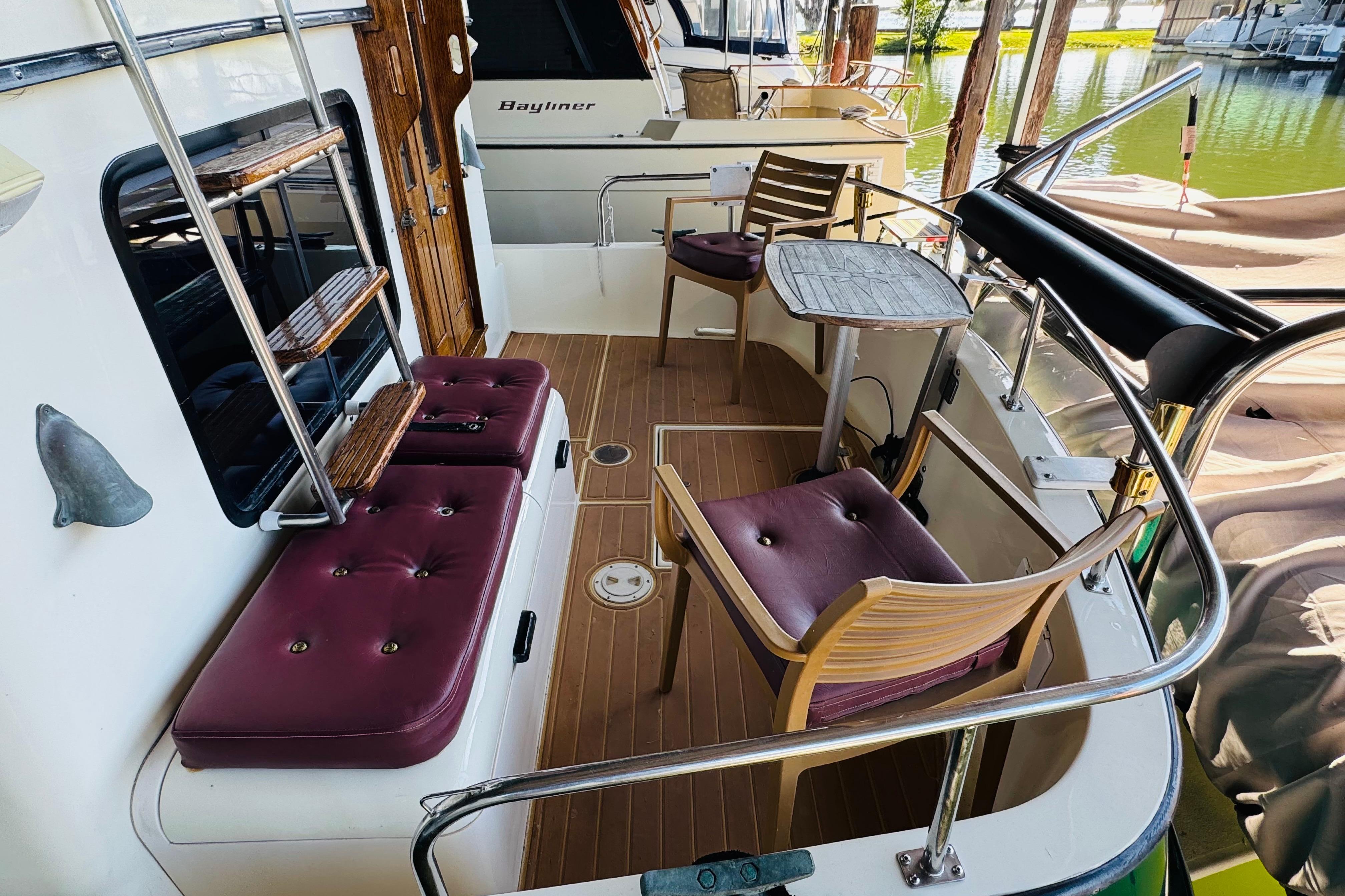 1996 Nordic Tug 32 boat deck with seating, table, and wooden accents.