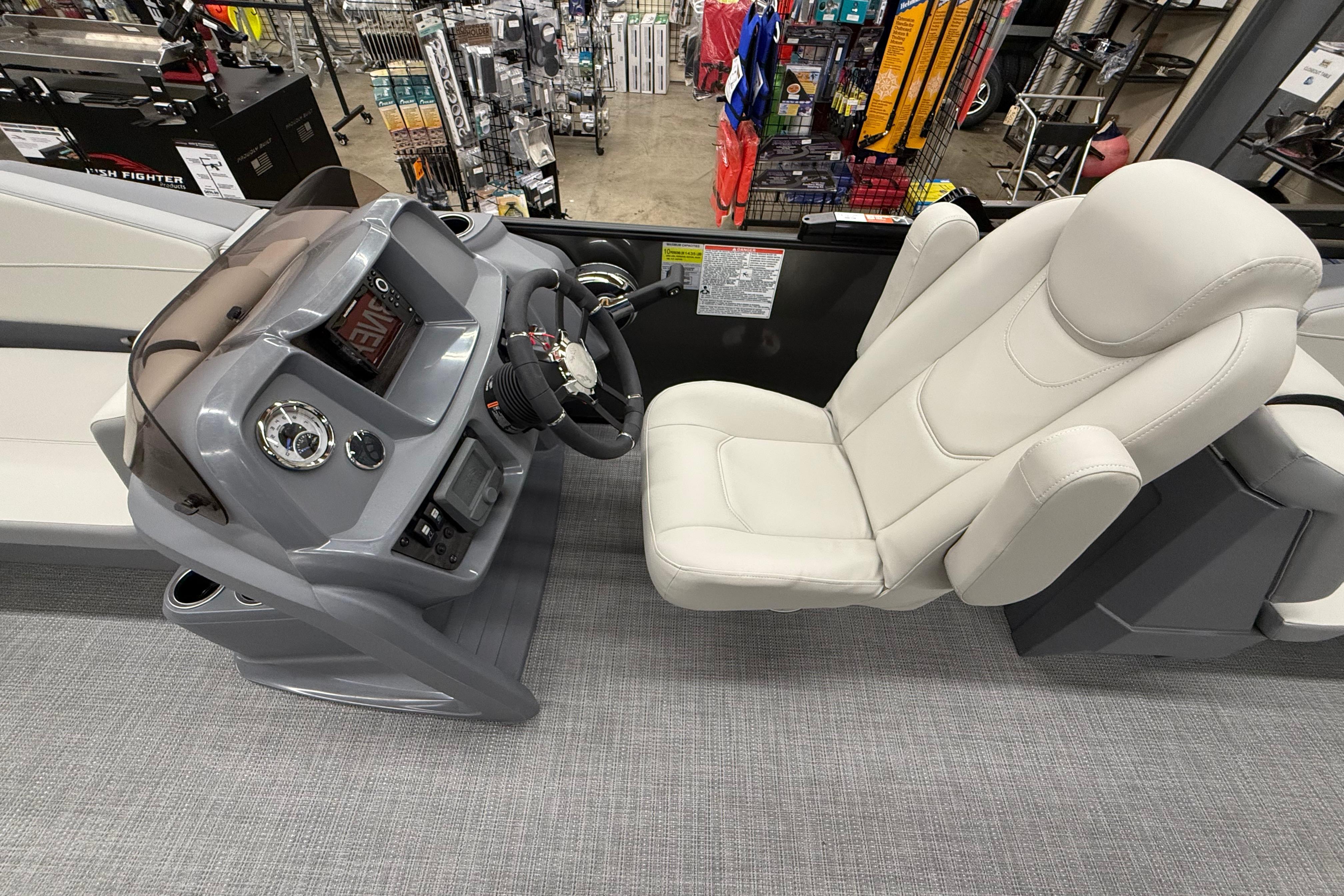2025 SunChaser Lucerne 22 LR DH boat interior with steering console and plush captain's chair.
