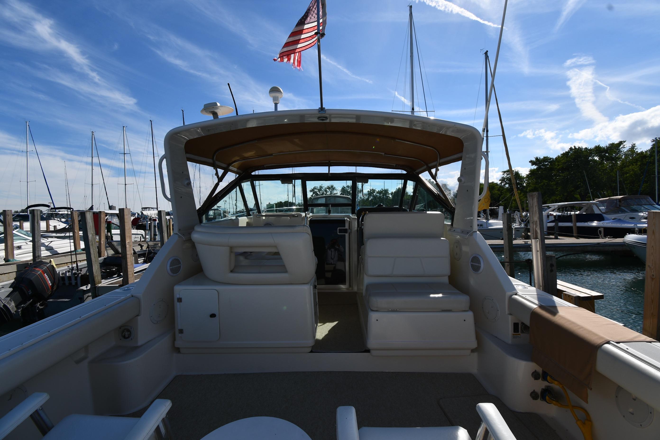 1998 Tiara Yachts 3100 Open at marina, featuring spacious cockpit and American flag.