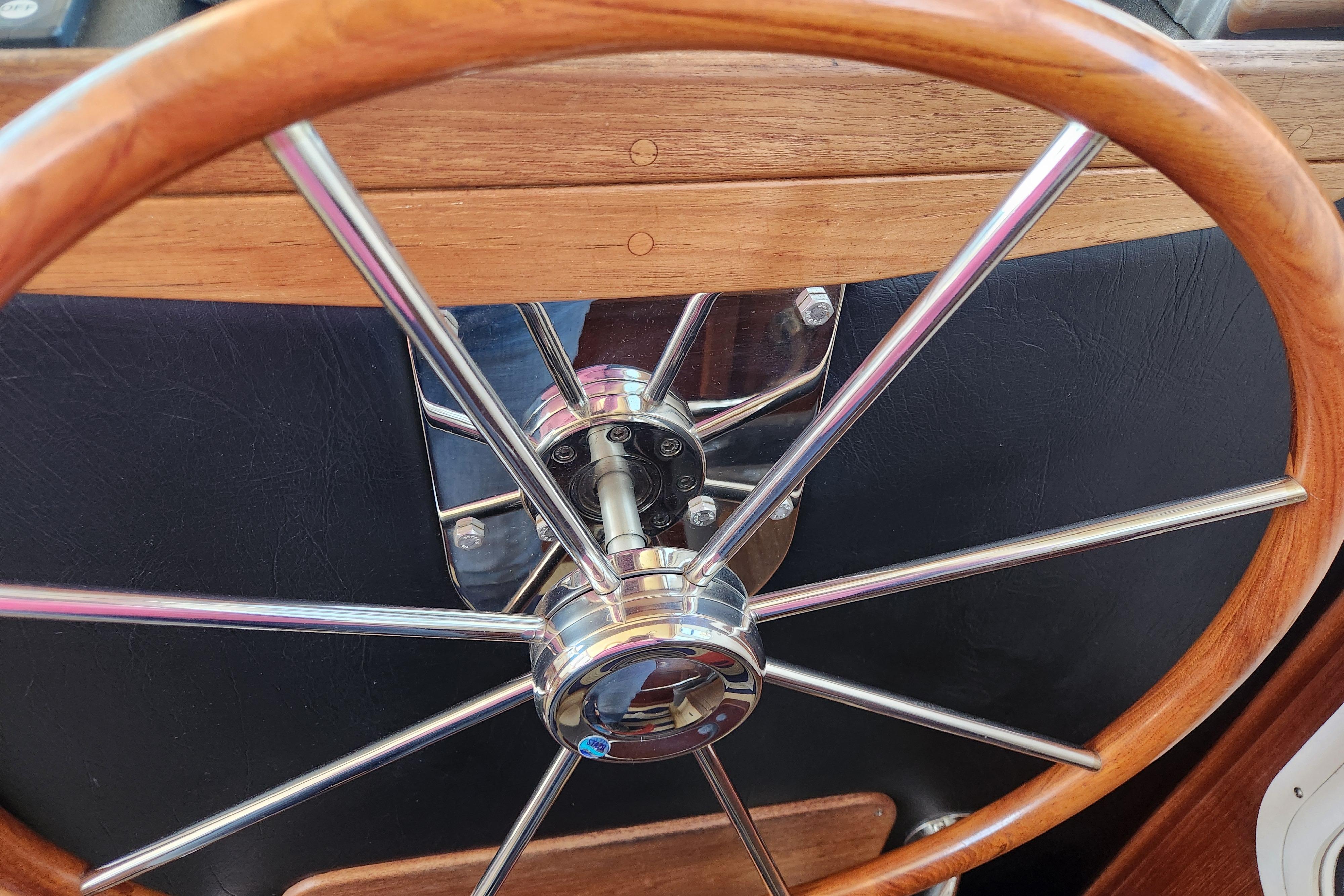 Wooden and metal steering wheel of a 2006 American Tug AT boat.