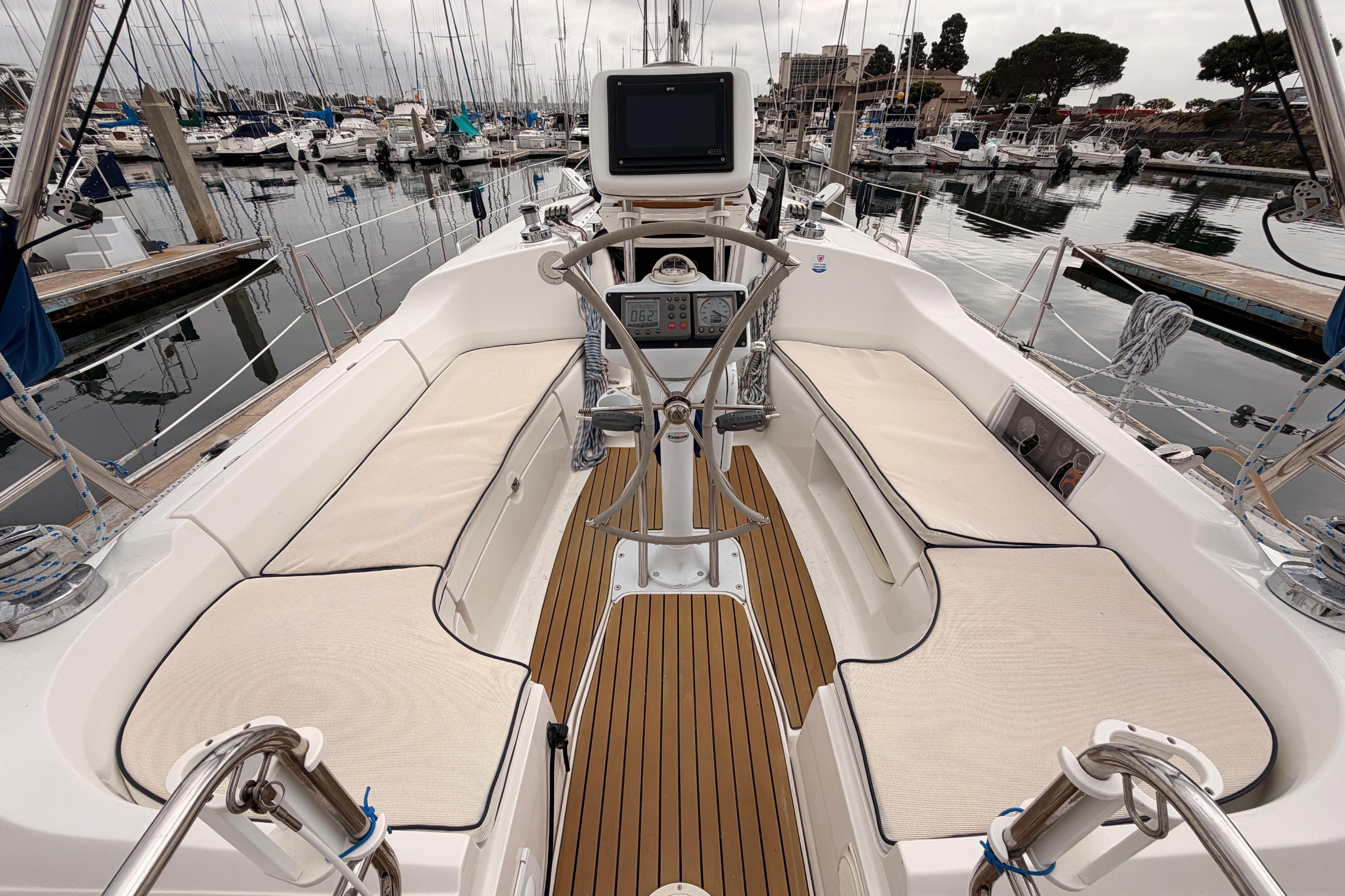 2009 Hunter 38 sailboat cockpit with cushioned seating and navigation equipment at marina.