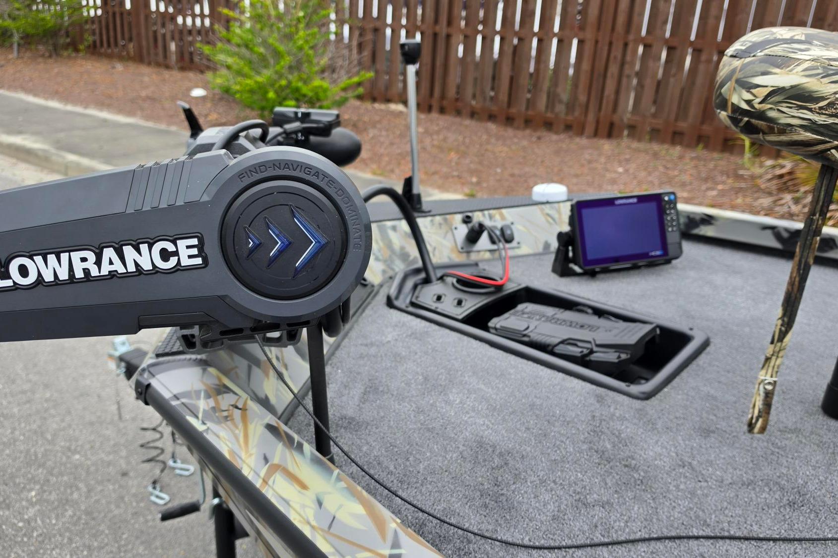2026 Ranger RT178 boat with Lowrance navigation system and camo seat, parked near a wooden fence.
