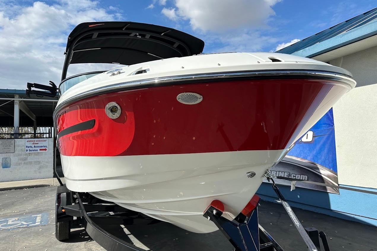 2026 Sea Ray SDX 230 Surf boat with red and white hull on trailer.