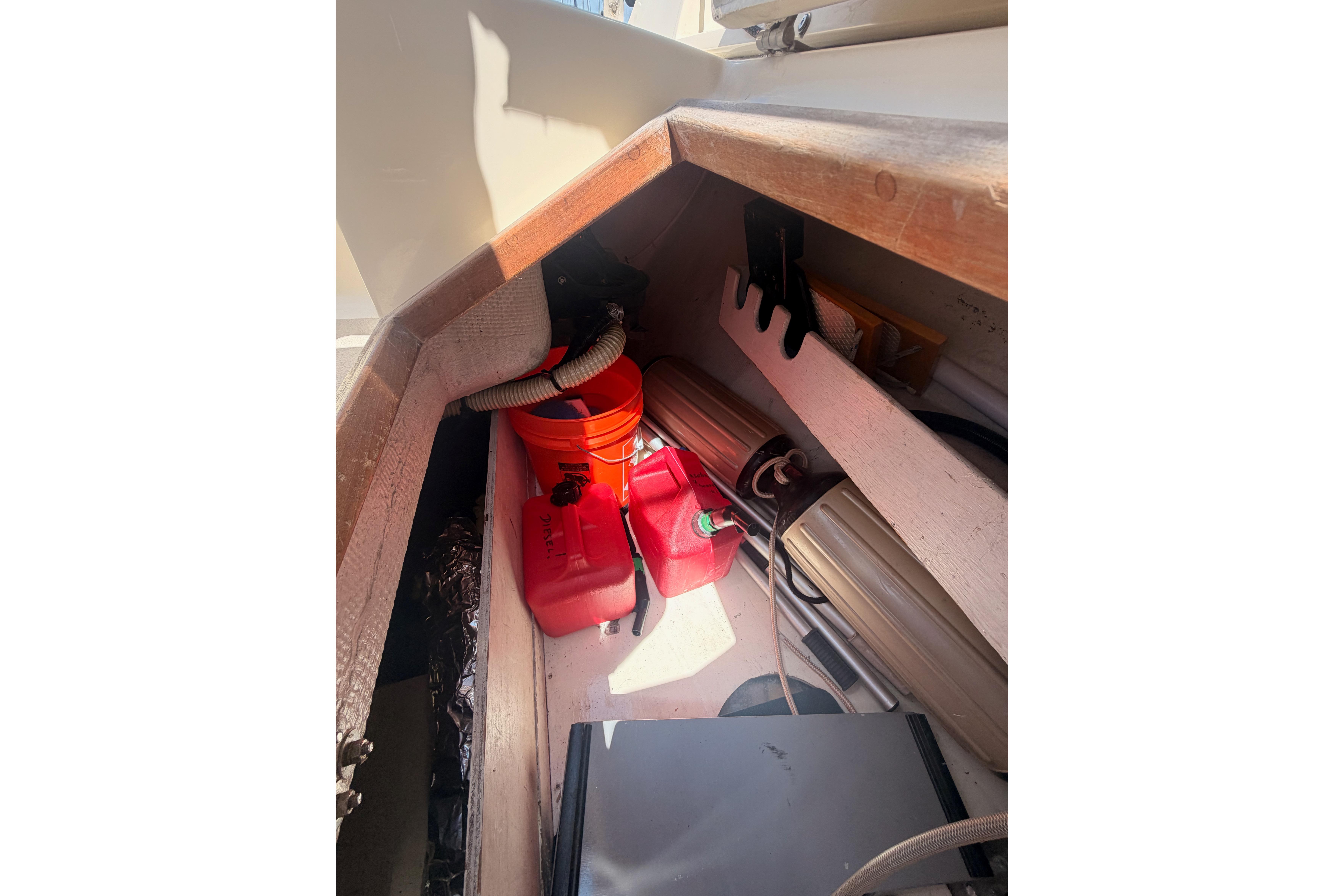 Storage compartment in a 1991 Caliber 33 sailboat with fuel containers and equipment.