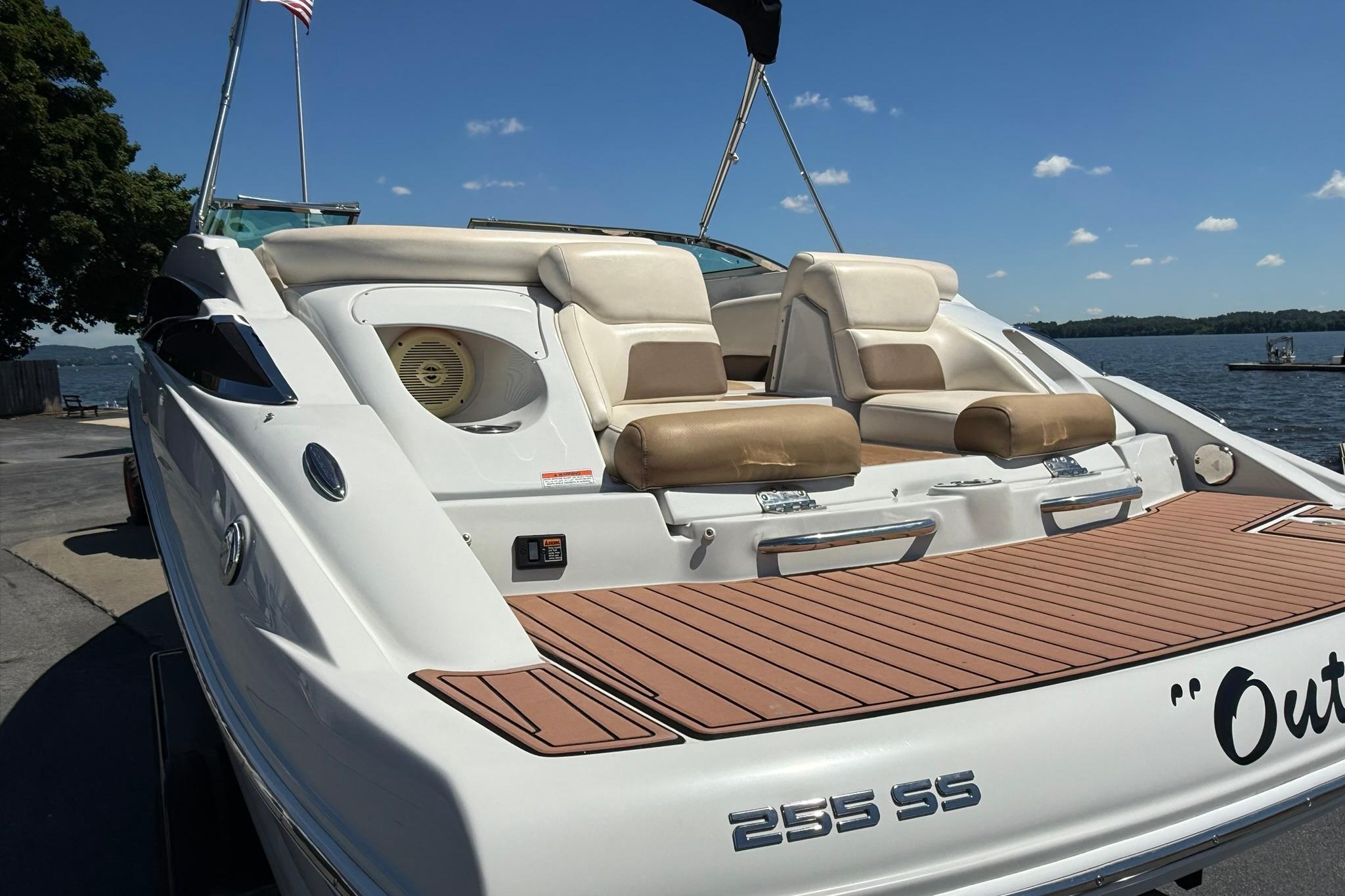 2016 Crownline 255 SS boat with tan seating, docked by a lake under a clear sky.