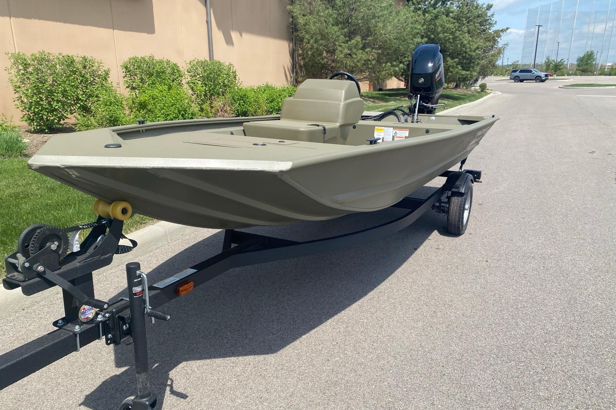 2026 Tracker Grizzly 1648 SC boat on trailer, parked outdoors on a sunny day.