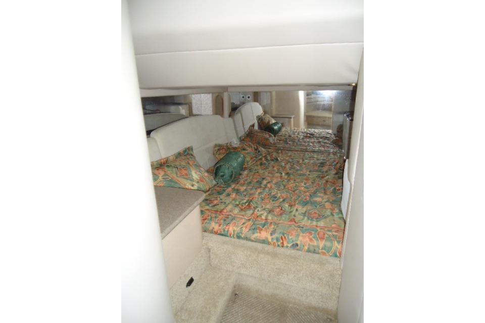 Interior cabin of a 1999 Formula 400 Super Sport with patterned bedding and cozy layout.