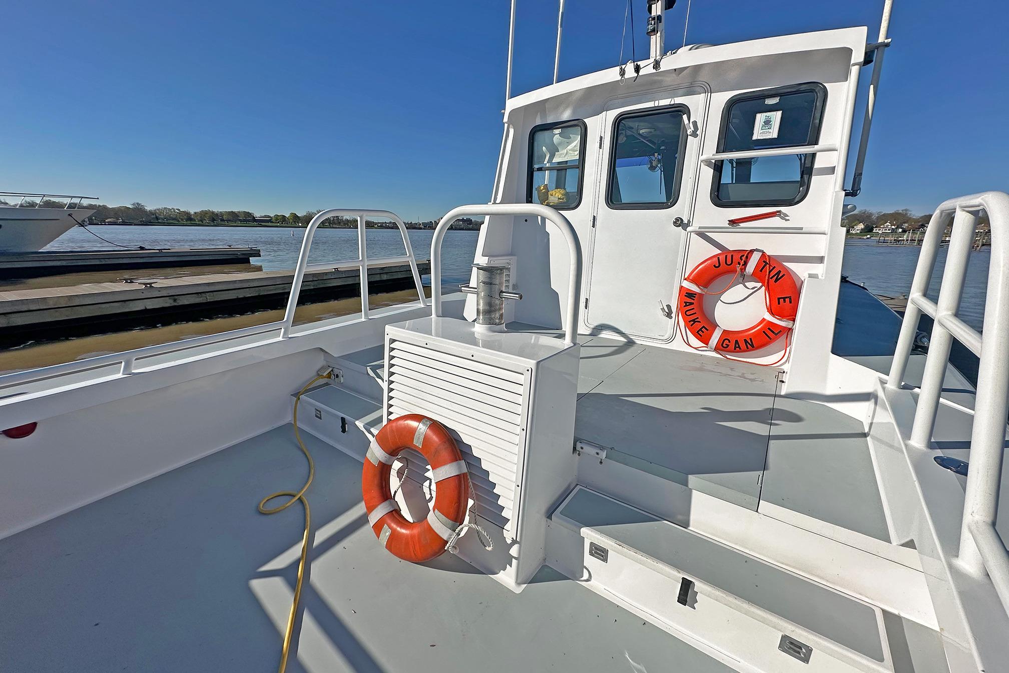 1990 Boston Whaler 36 Defiance boat docked, featuring life rings and clear blue sky.