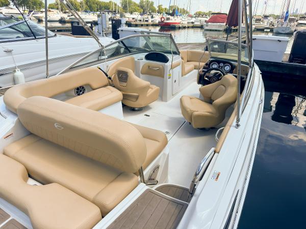 2023 Crownline 215 XS boat with beige interior, docked at a marina.