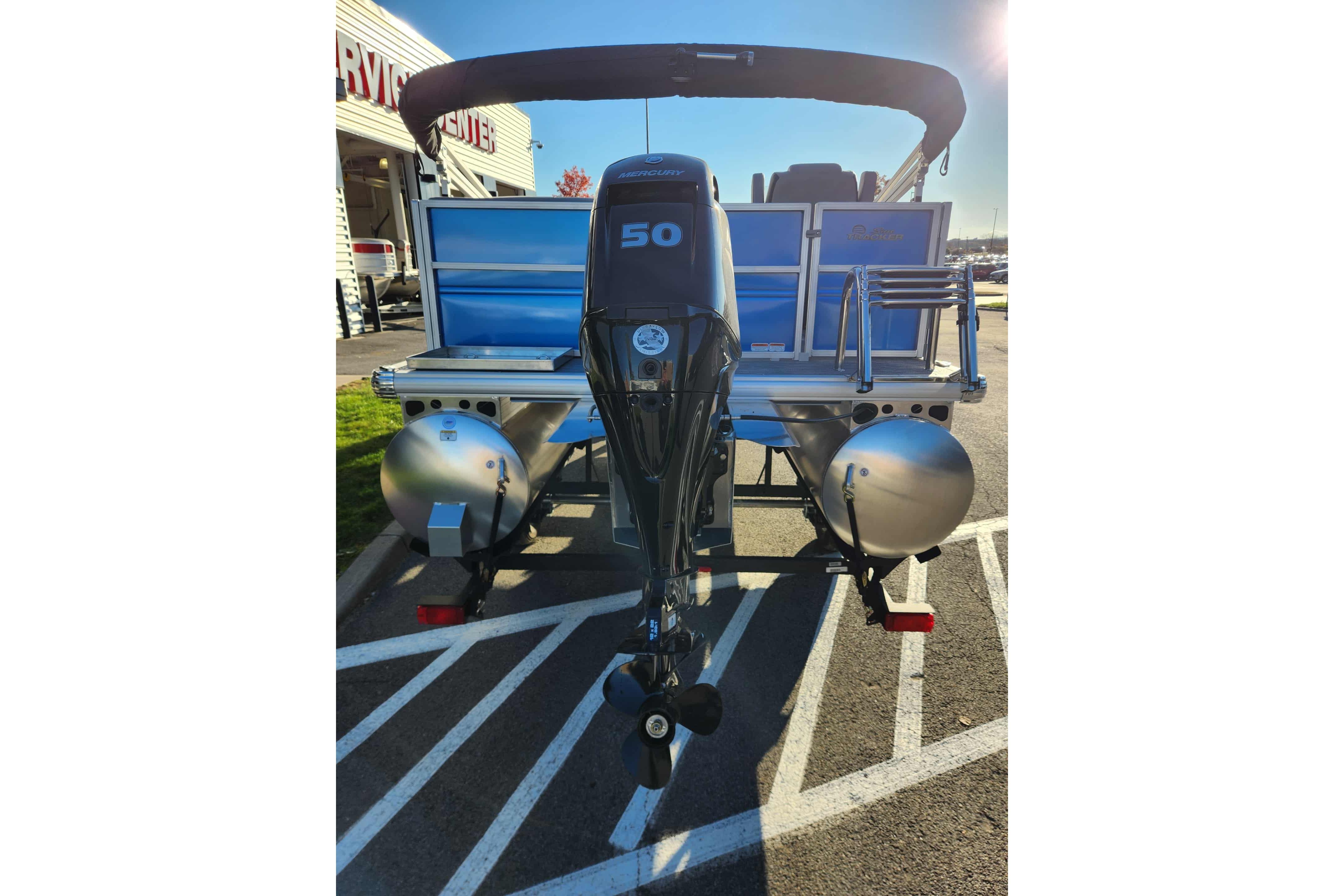 2026 Sun Tracker Party Barge 16 DLX pontoon boat with 50 HP engine, rear view.