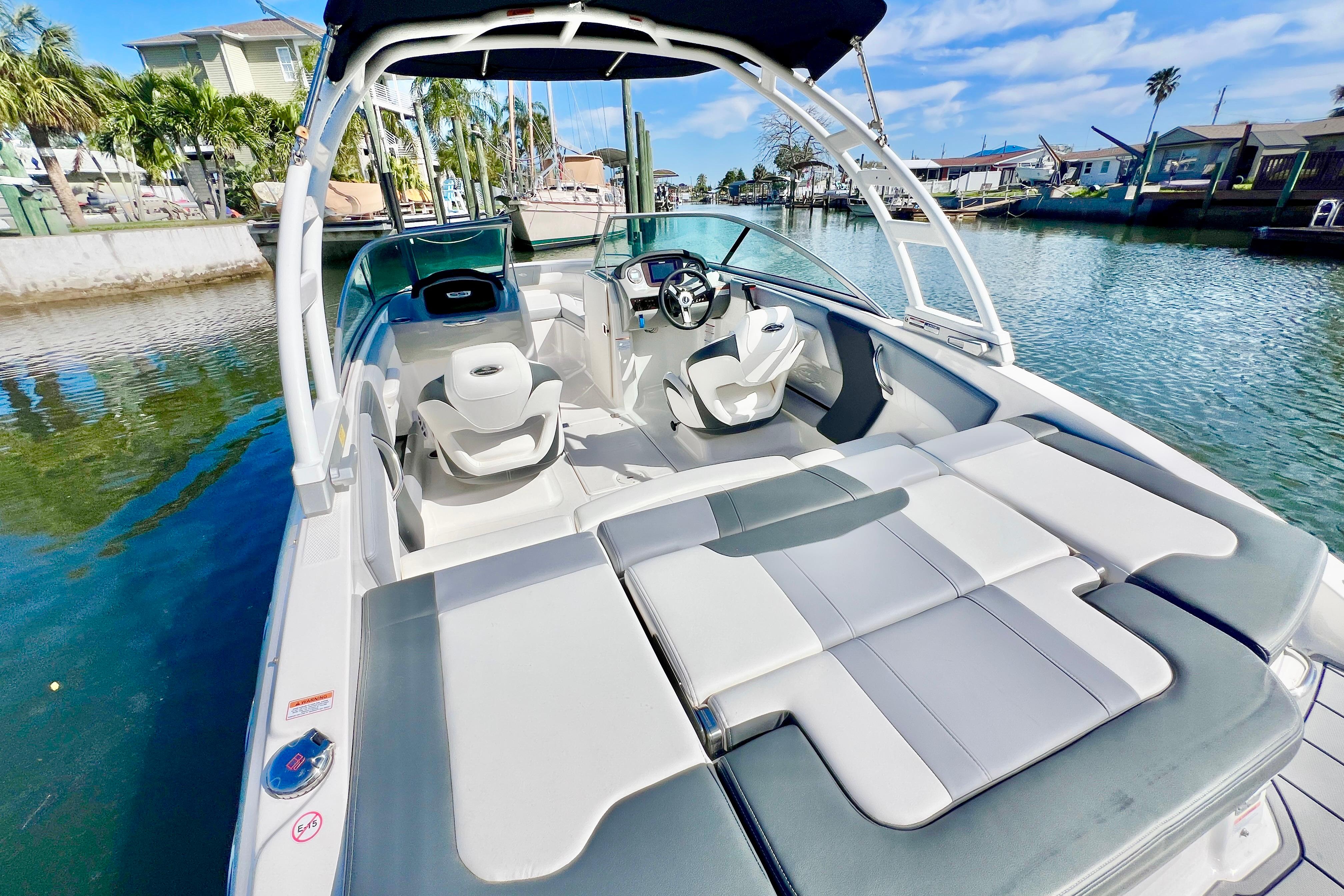 2023 Chaparral 21 SSi OB boat interior with seating, docked by a canal.