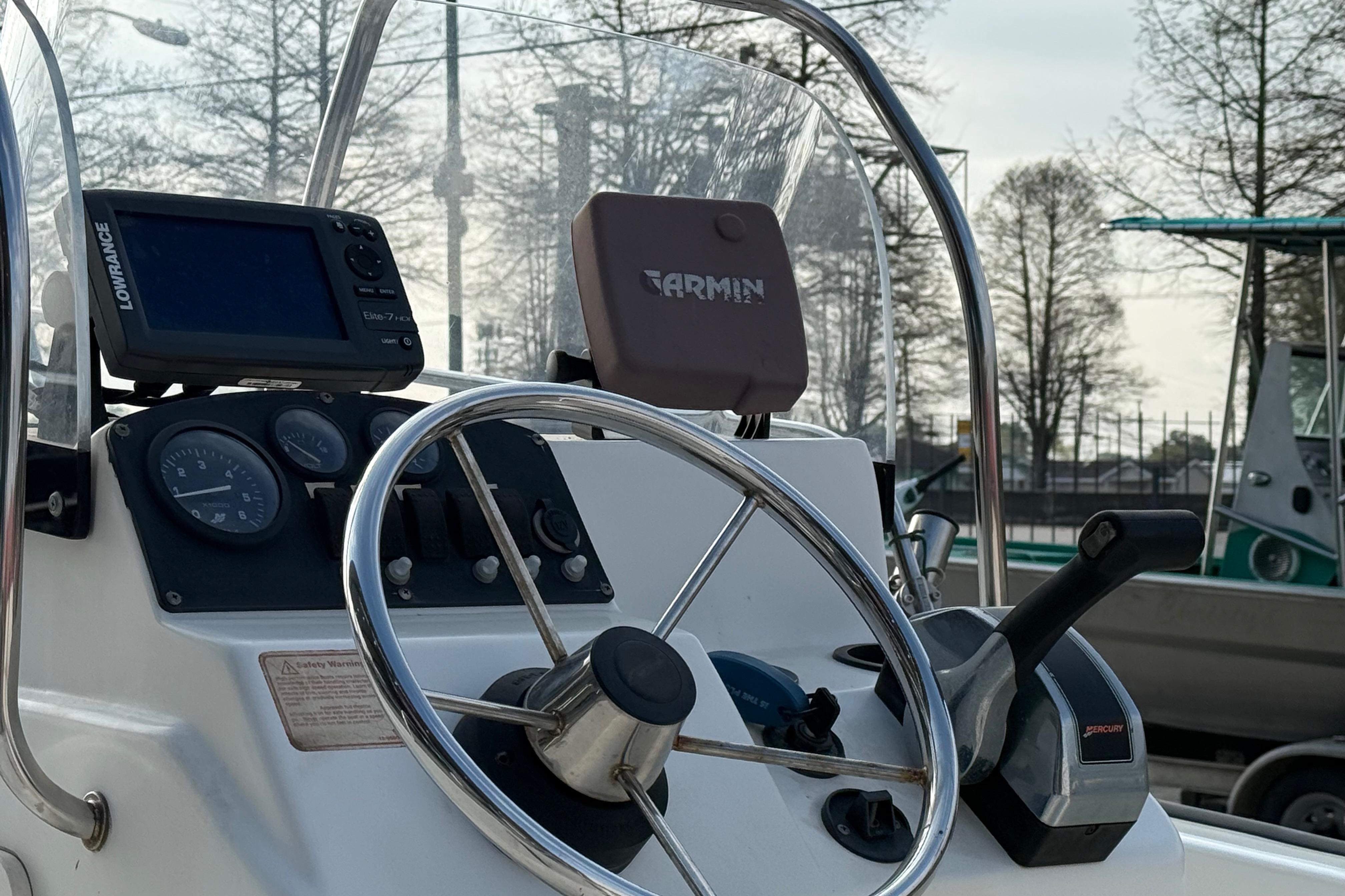 2005 Boston Whaler 17 Montauk boat dashboard with steering wheel and navigation equipment.