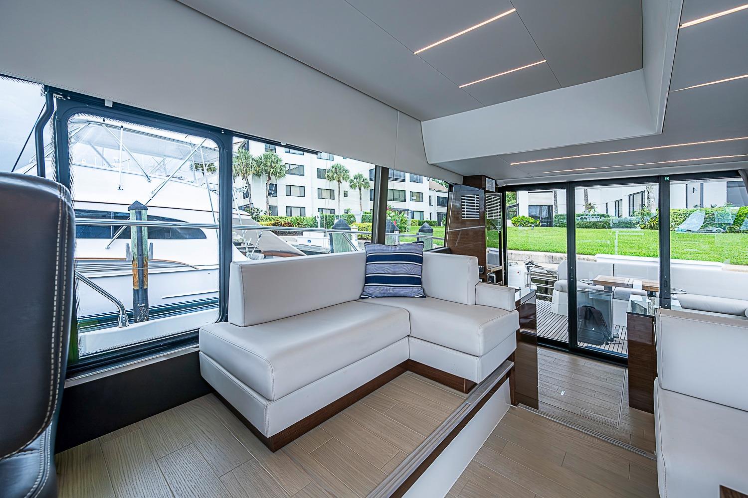 Luxurious interior of 2021 Prestige 520 yacht with modern seating and large windows.
