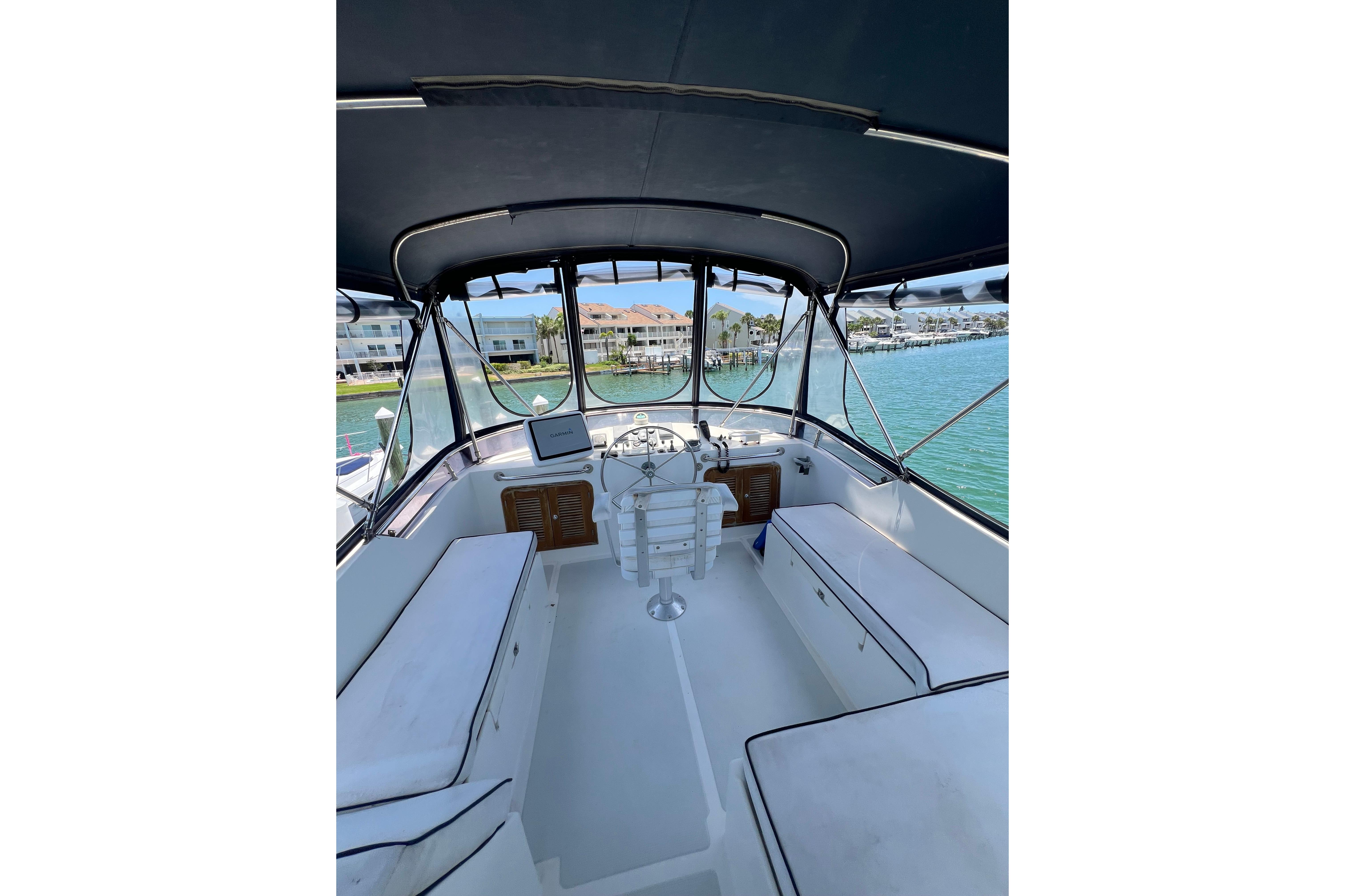 2007 Heritage East 36 Sundeck Trawler interior with helm, seating, and marina view.