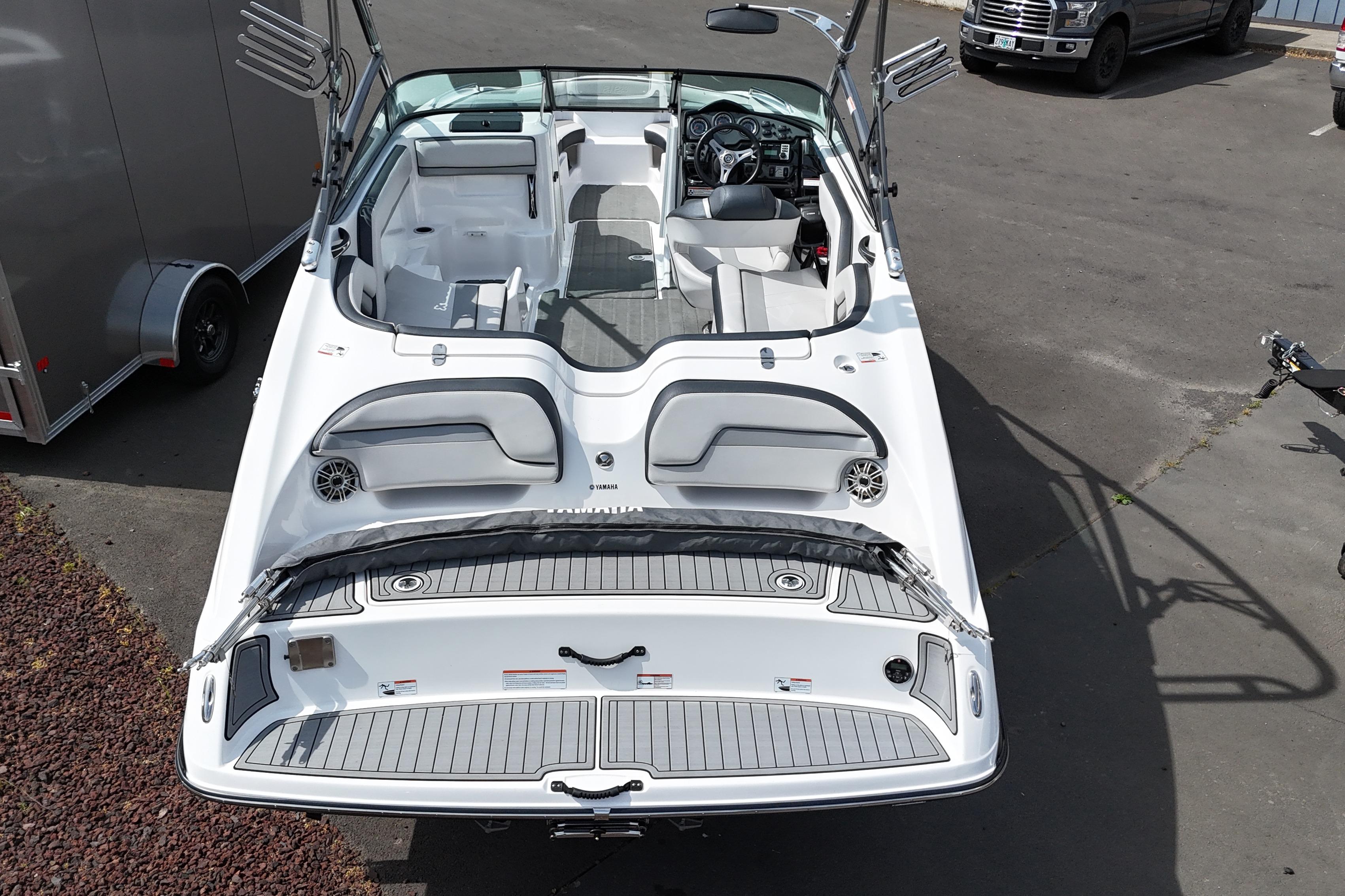 2016 Yamaha Boats 212X, white interior, parked on pavement, showcasing seating and dashboard.