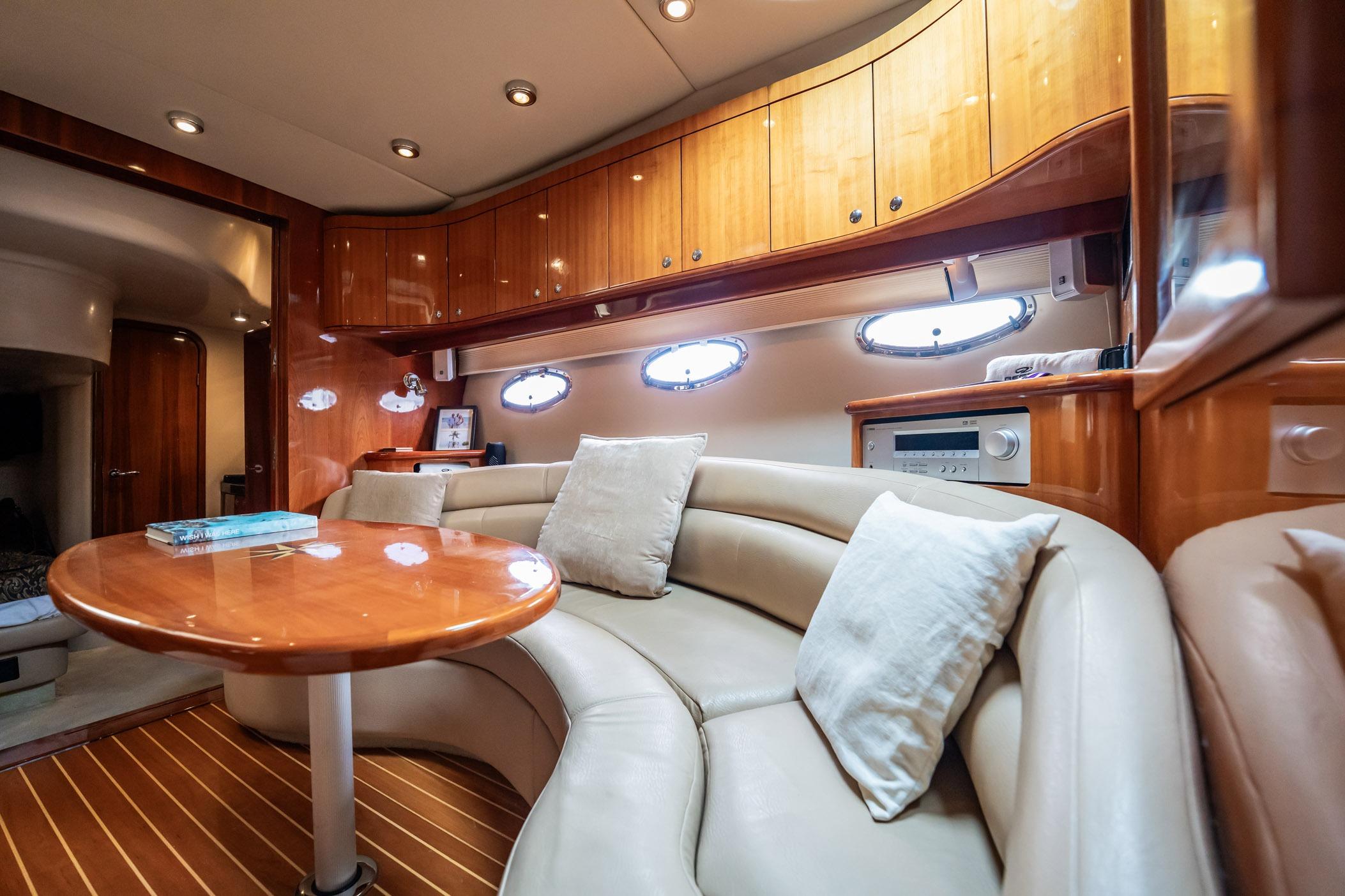 Luxurious interior of 2008 Regal Commodore 4460 yacht with plush seating and wooden cabinetry.