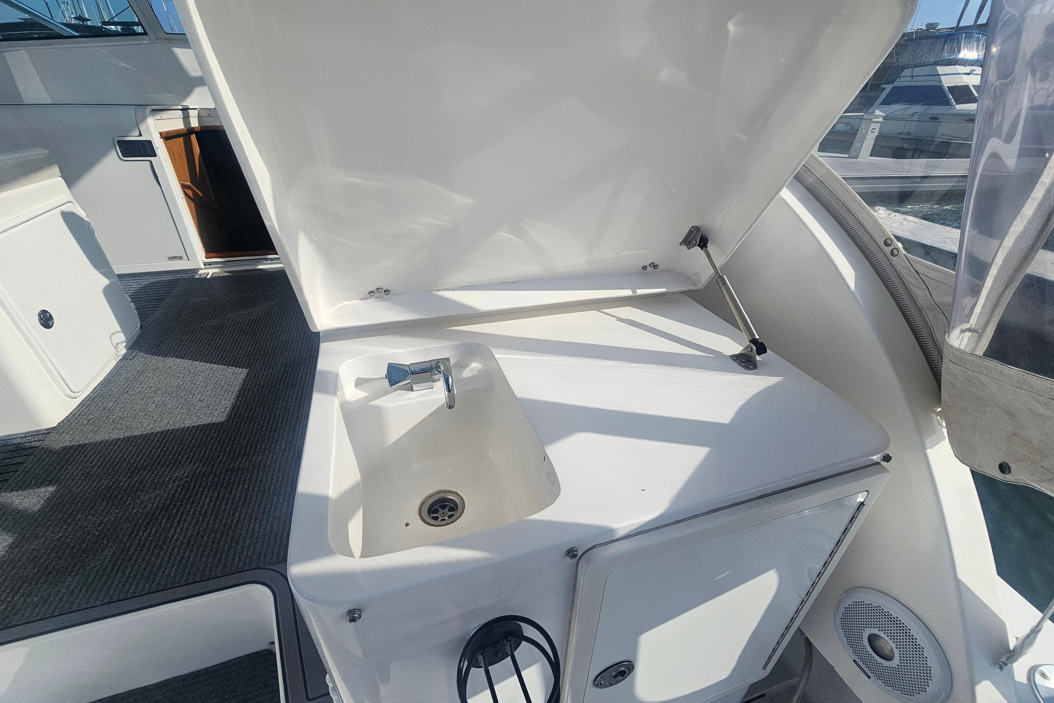 2003 Topaz 32 Express boat interior with open sink compartment and carpeted flooring.