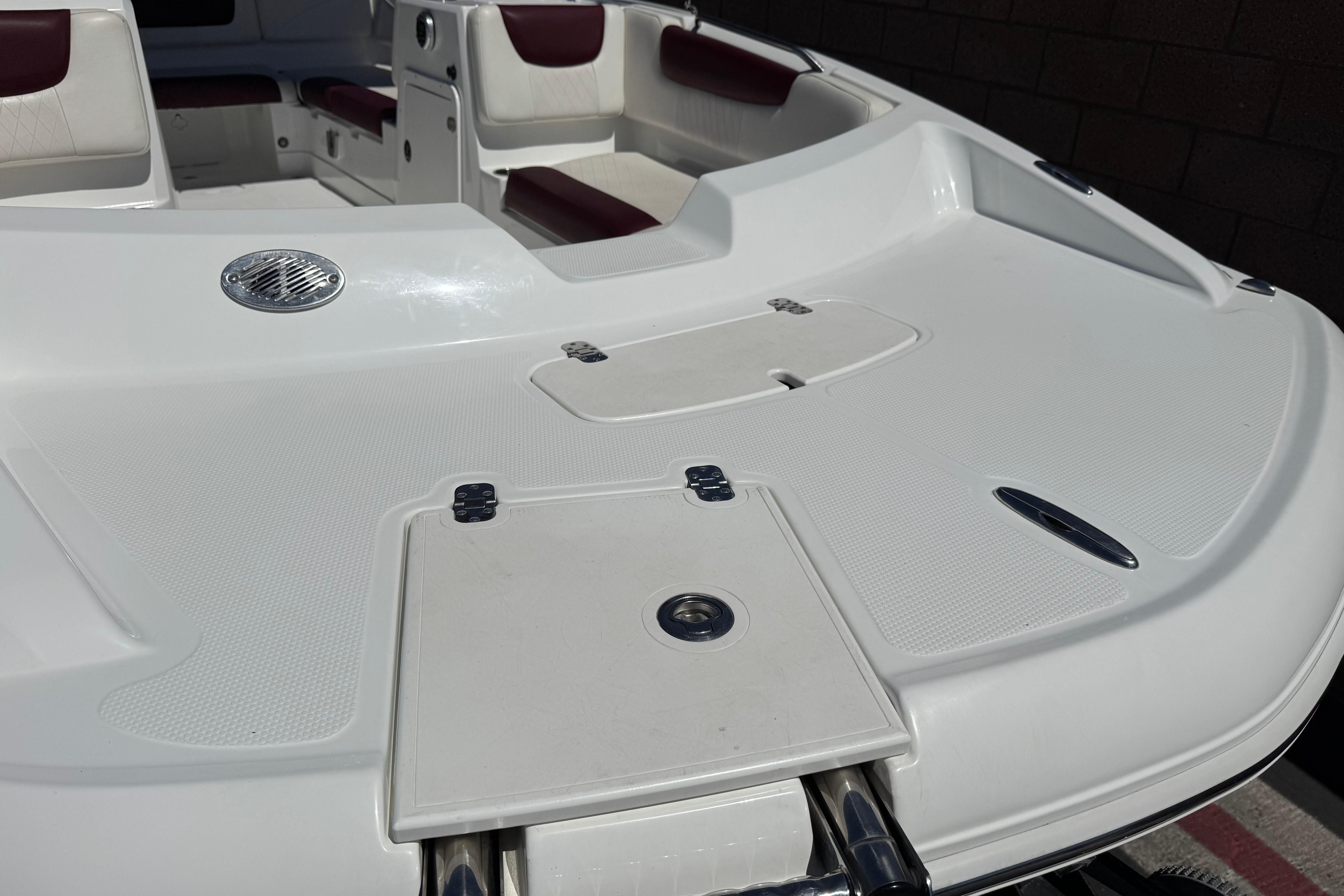 2017 Tahoe 2150 boat interior with white and maroon seating, featuring storage compartments.