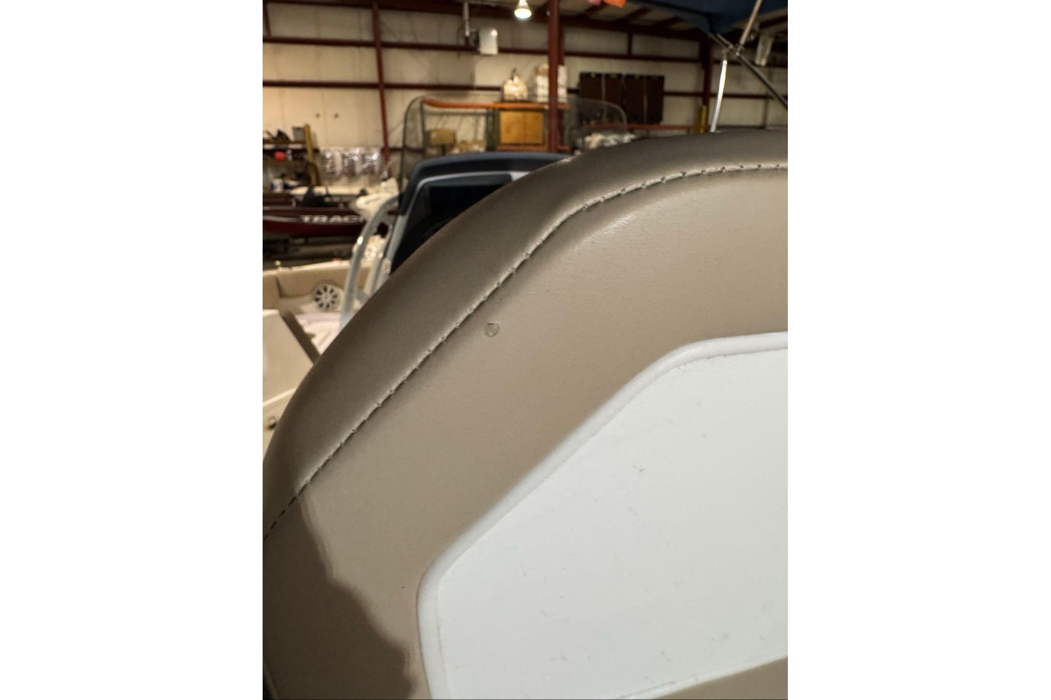 Close-up of 2026 Tahoe 2150 CC boat seat in a warehouse setting.