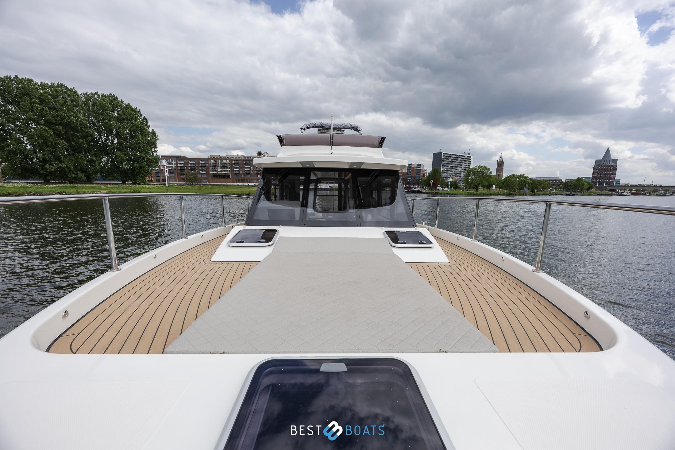 2023 Cobra Yachts Futura 36 Premium Fly on a scenic river with city skyline.