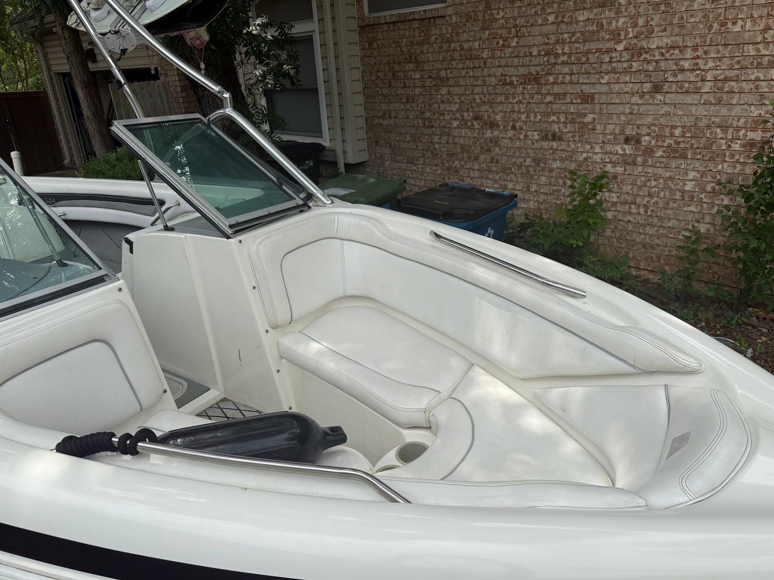 The image shows the white cockpit of a 1999 MasterCraft Prostar 205 with cushioned seating.