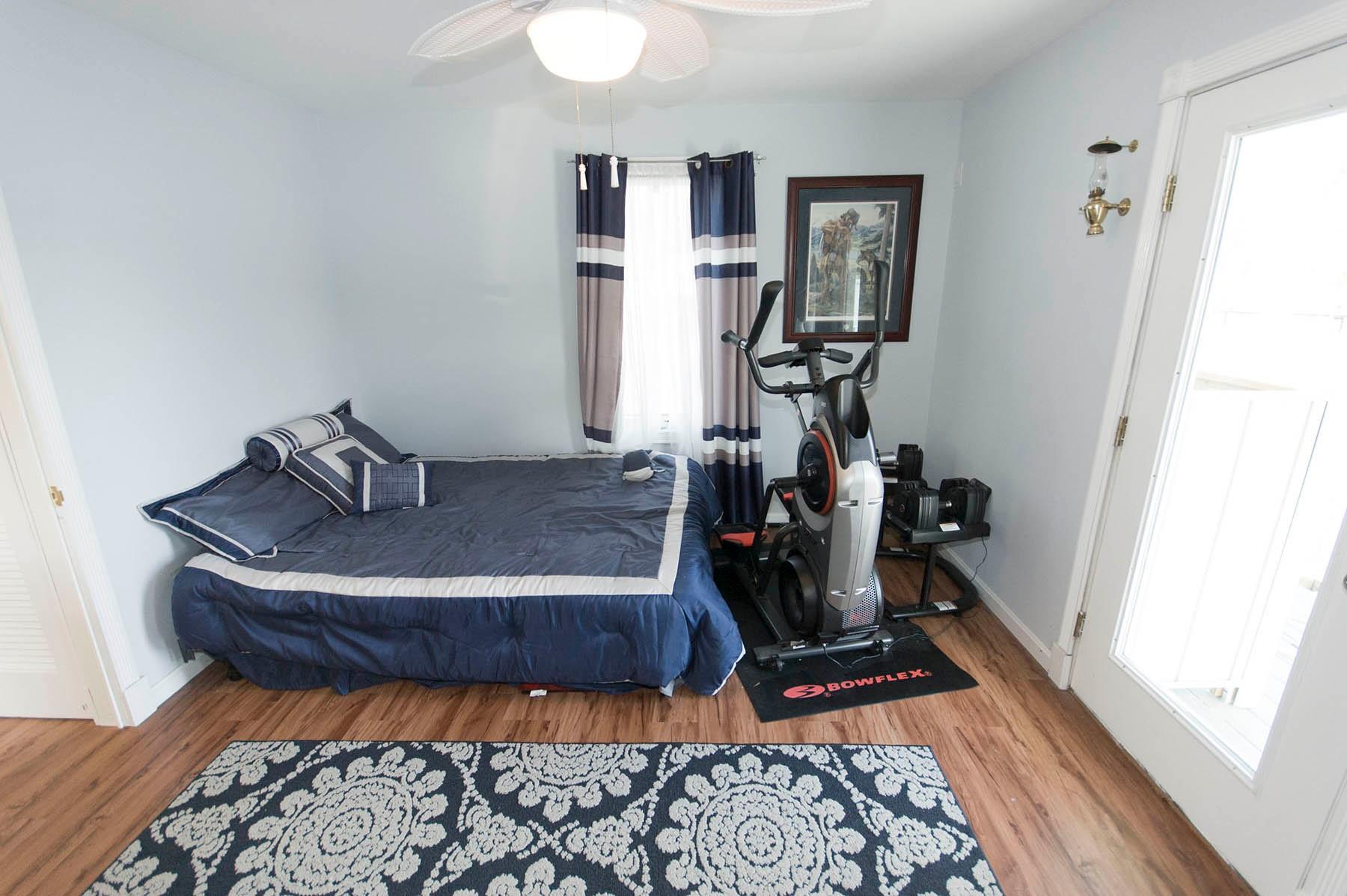 Bedroom in 2017 Chesapeake 48 Houseboat with bed, exercise bike, and decorative rug.