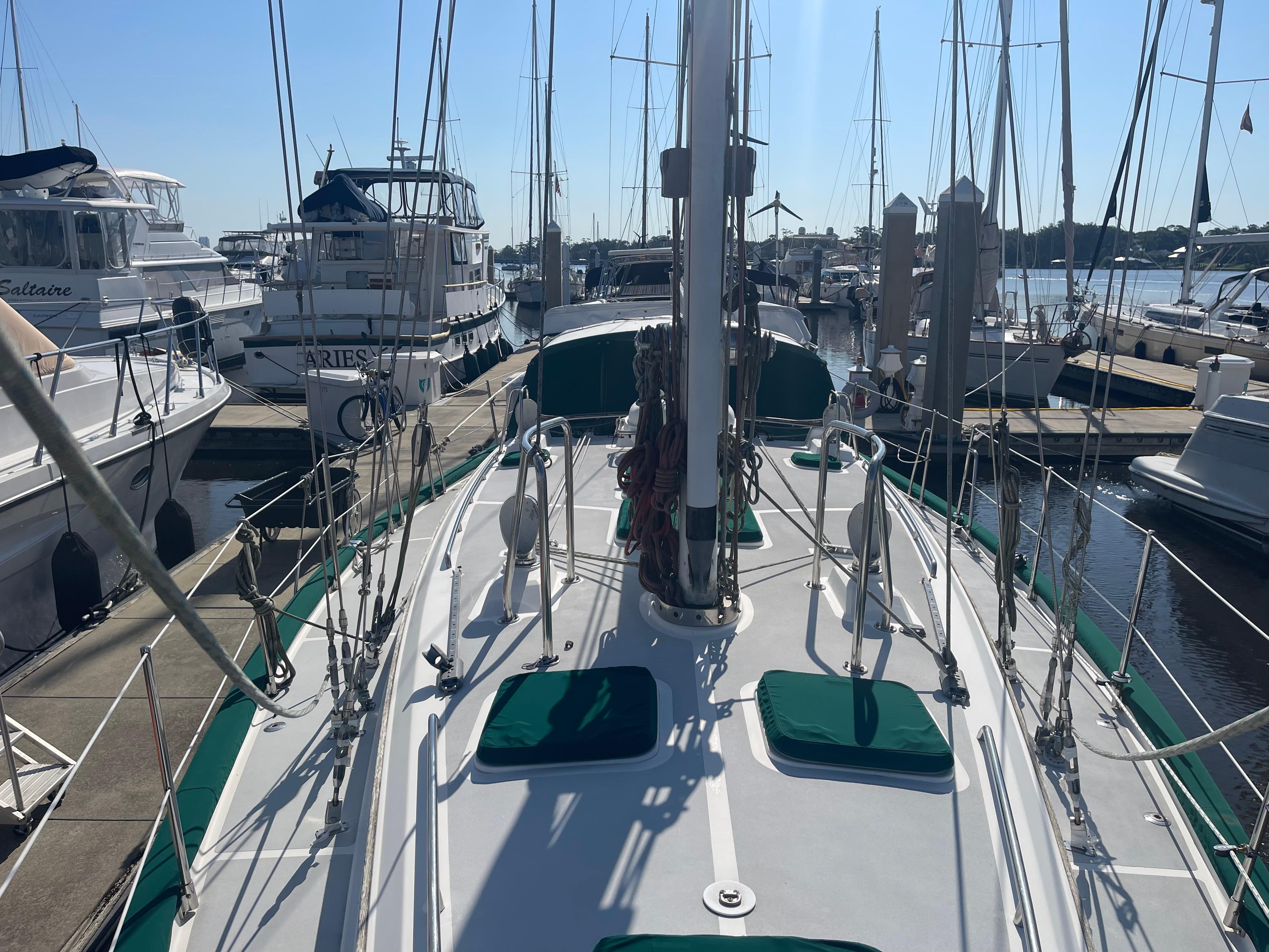 Sailboat Passport 47 AC Plan B 1995 docked at marina with other boats.