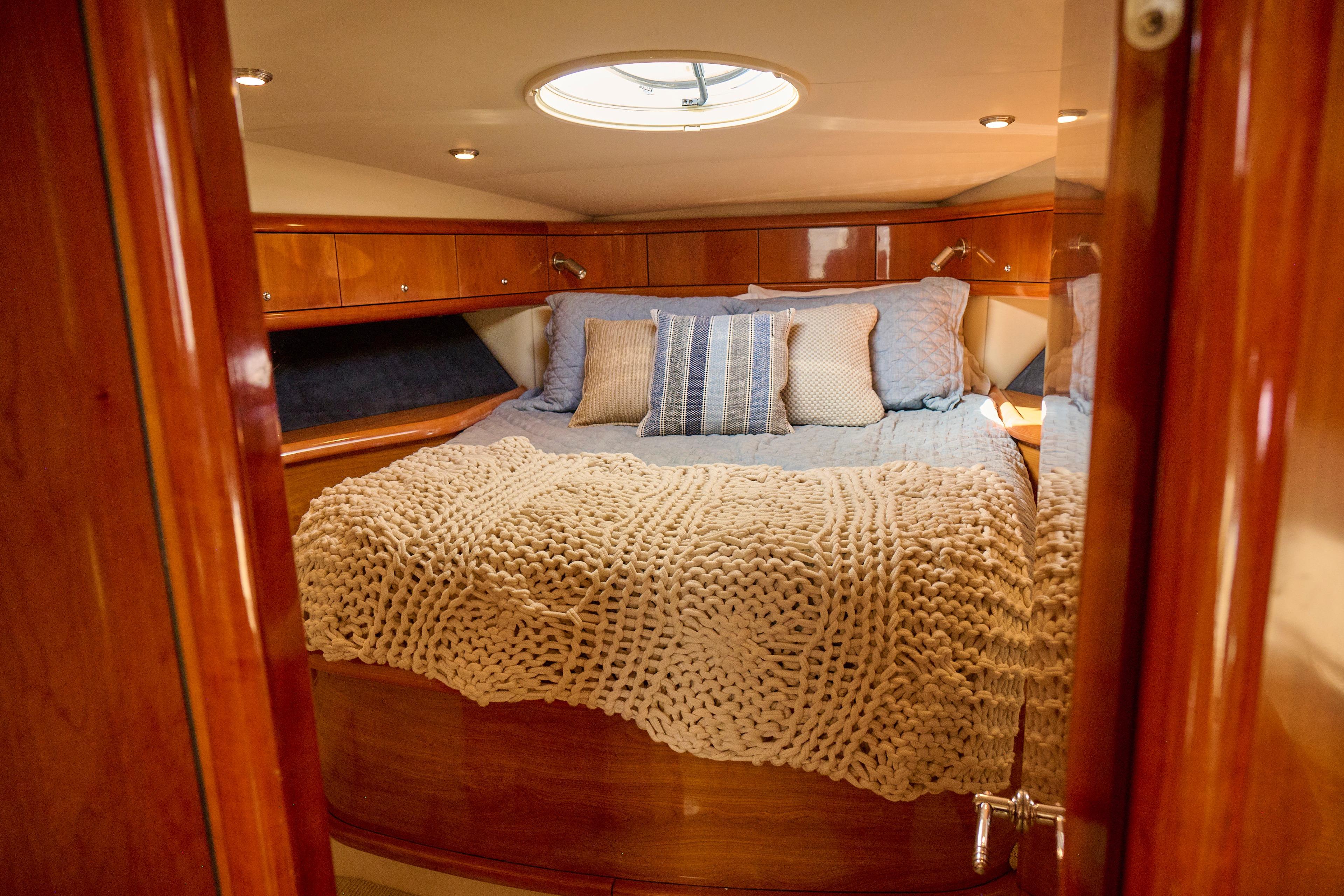 Luxurious cabin interior of 2000 Sunseeker Camargue 50 yacht with cozy bedding.