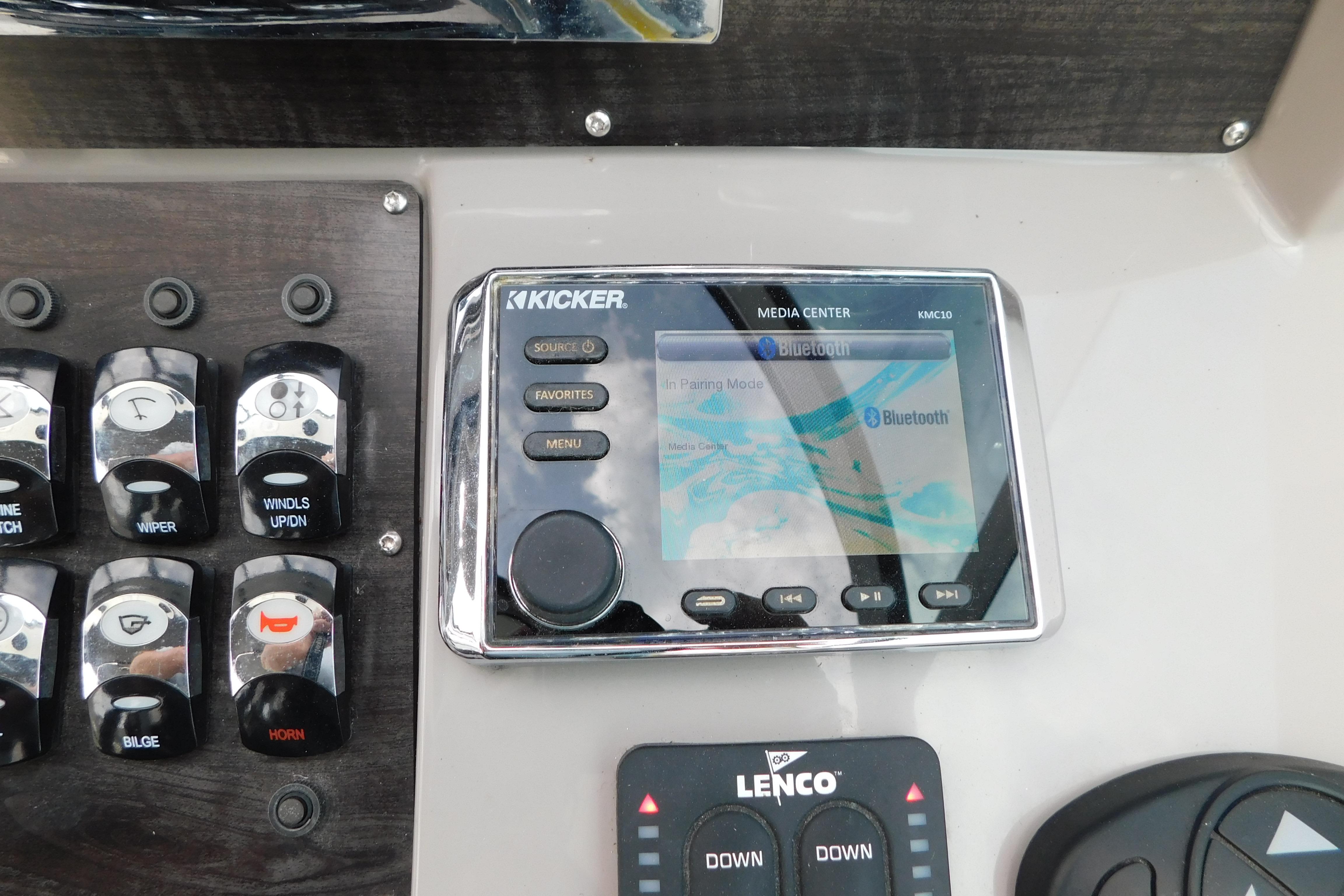 Control panel of a 2017 Rinker EX 320 boat featuring Kicker media center and switches.