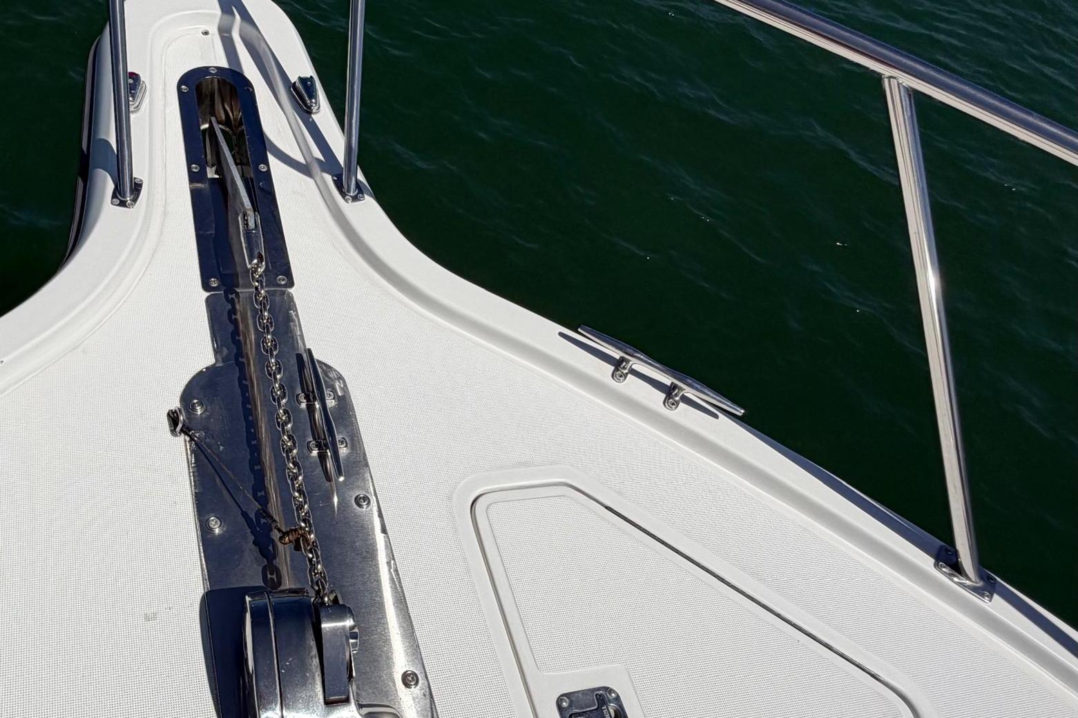 Bow of 1999 Tiara Yachts 4100 Open, featuring anchor chain and railing over water.