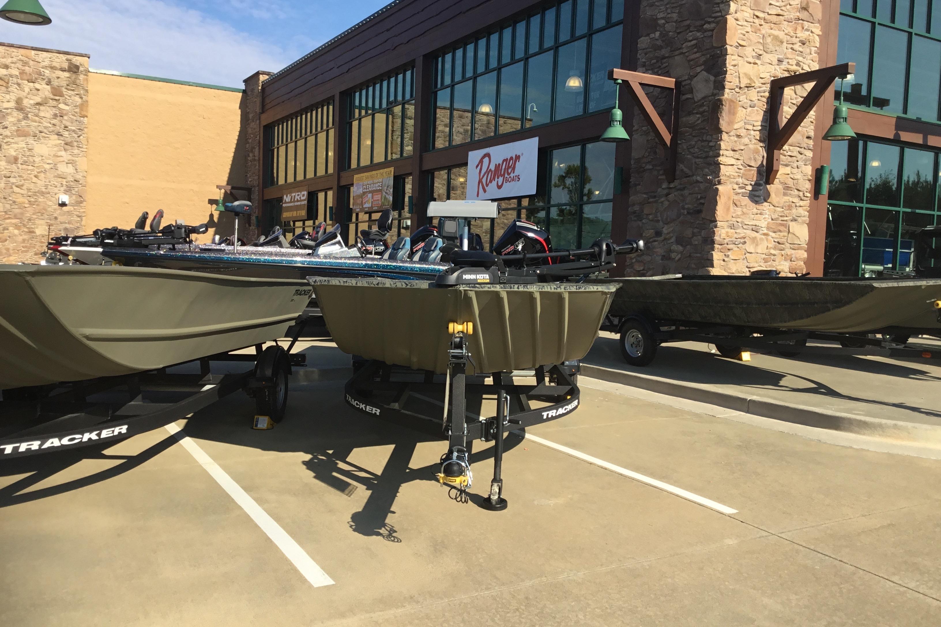 2025 Tracker Grizzly 2072 Utility boats displayed outside a store.
