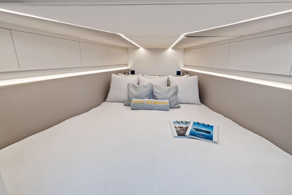 Luxurious interior cabin of 2024 Vanquish Yachts VQ55 with modern bedding and magazines.