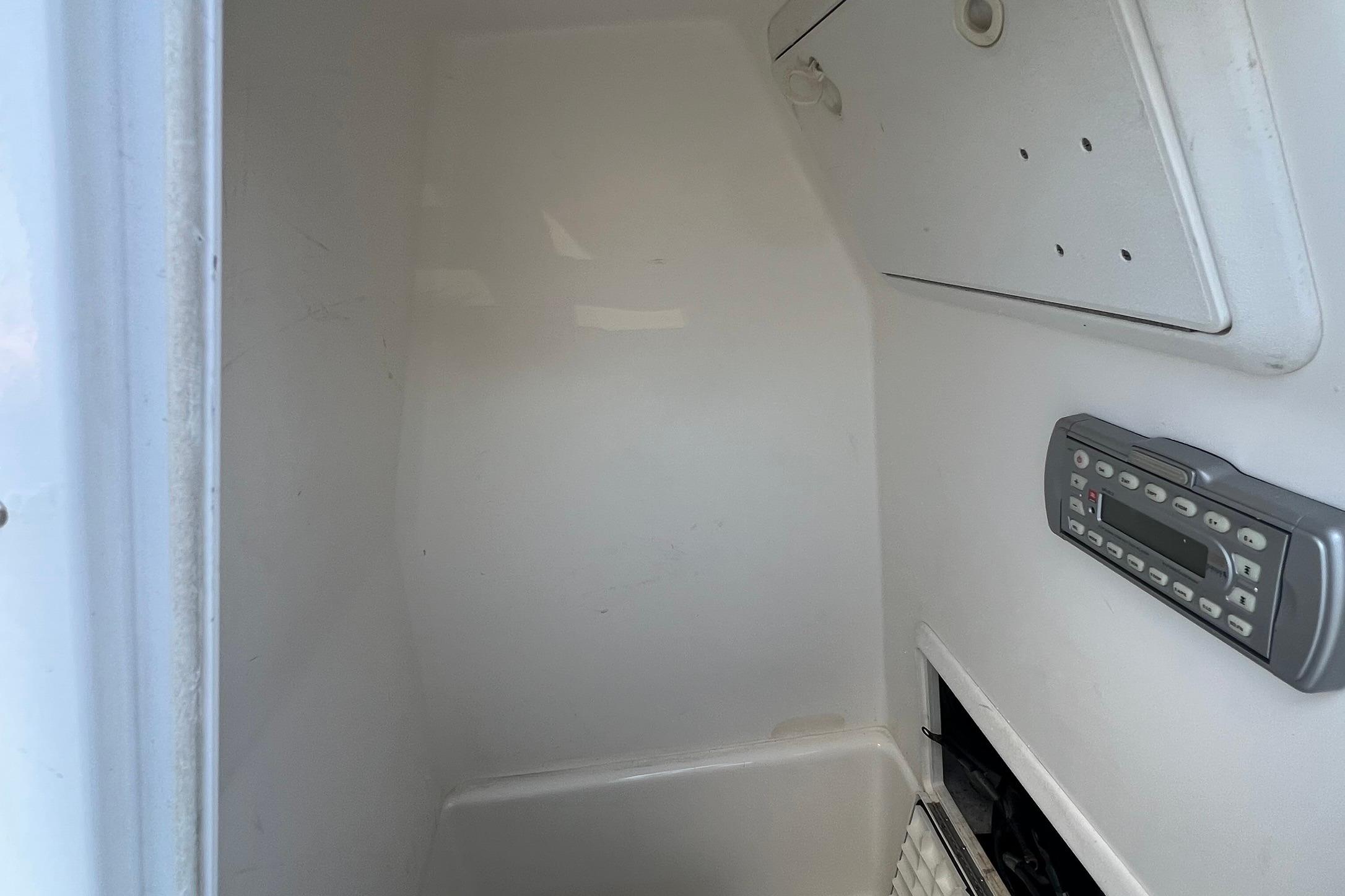 Interior of a 2006 Edgewater 245CC boat, featuring a control panel and storage compartment.