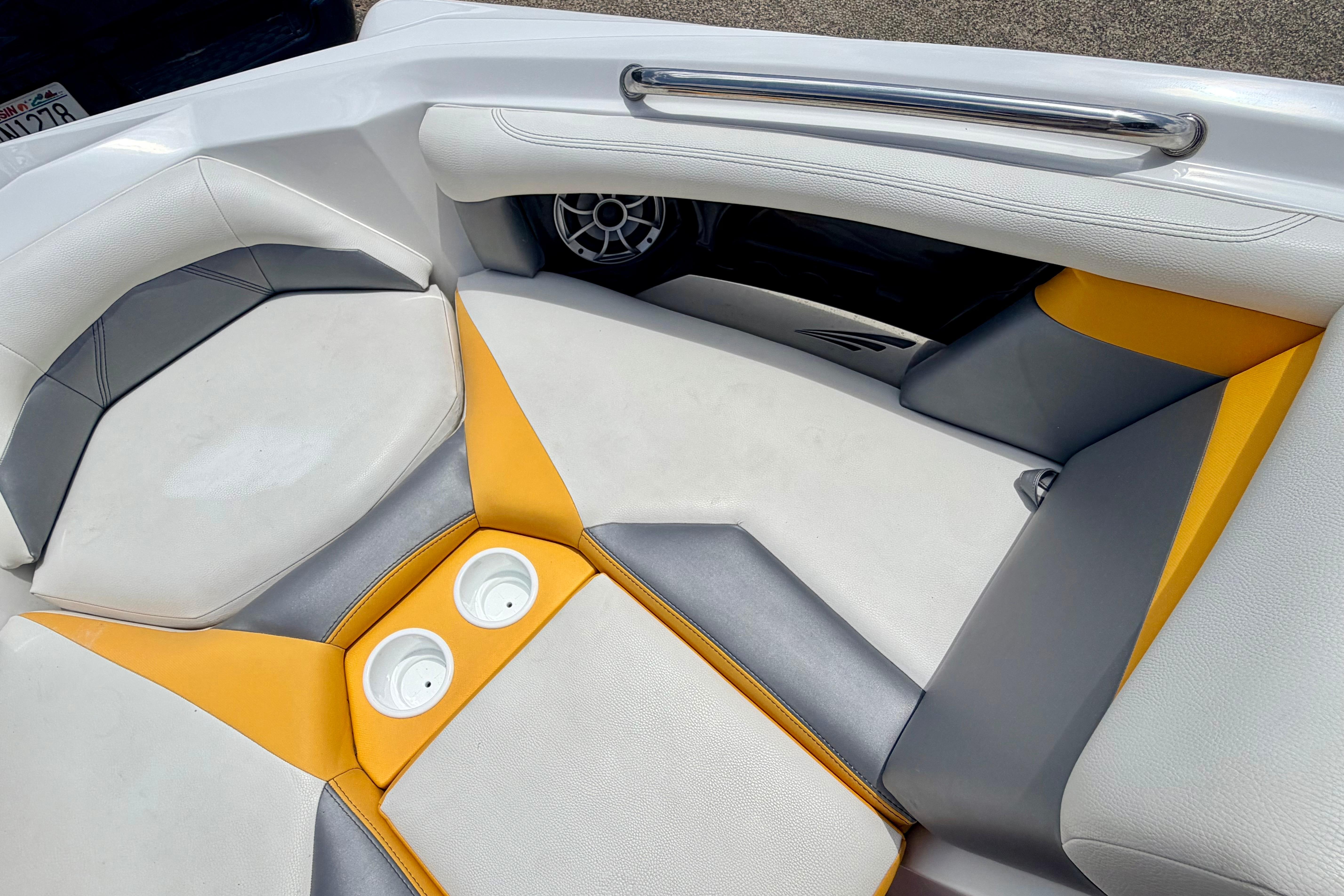 2014 Tigé R20 boat interior with white, yellow, and gray seating and cup holders.