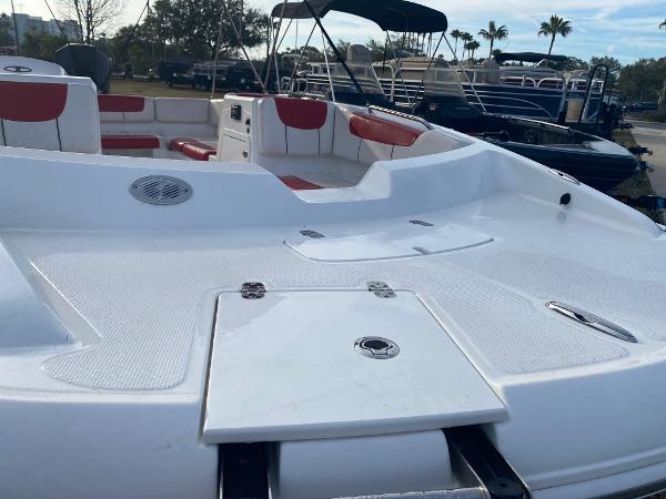 2022 Tahoe 2150 boat with white deck and red seating, docked outdoors.