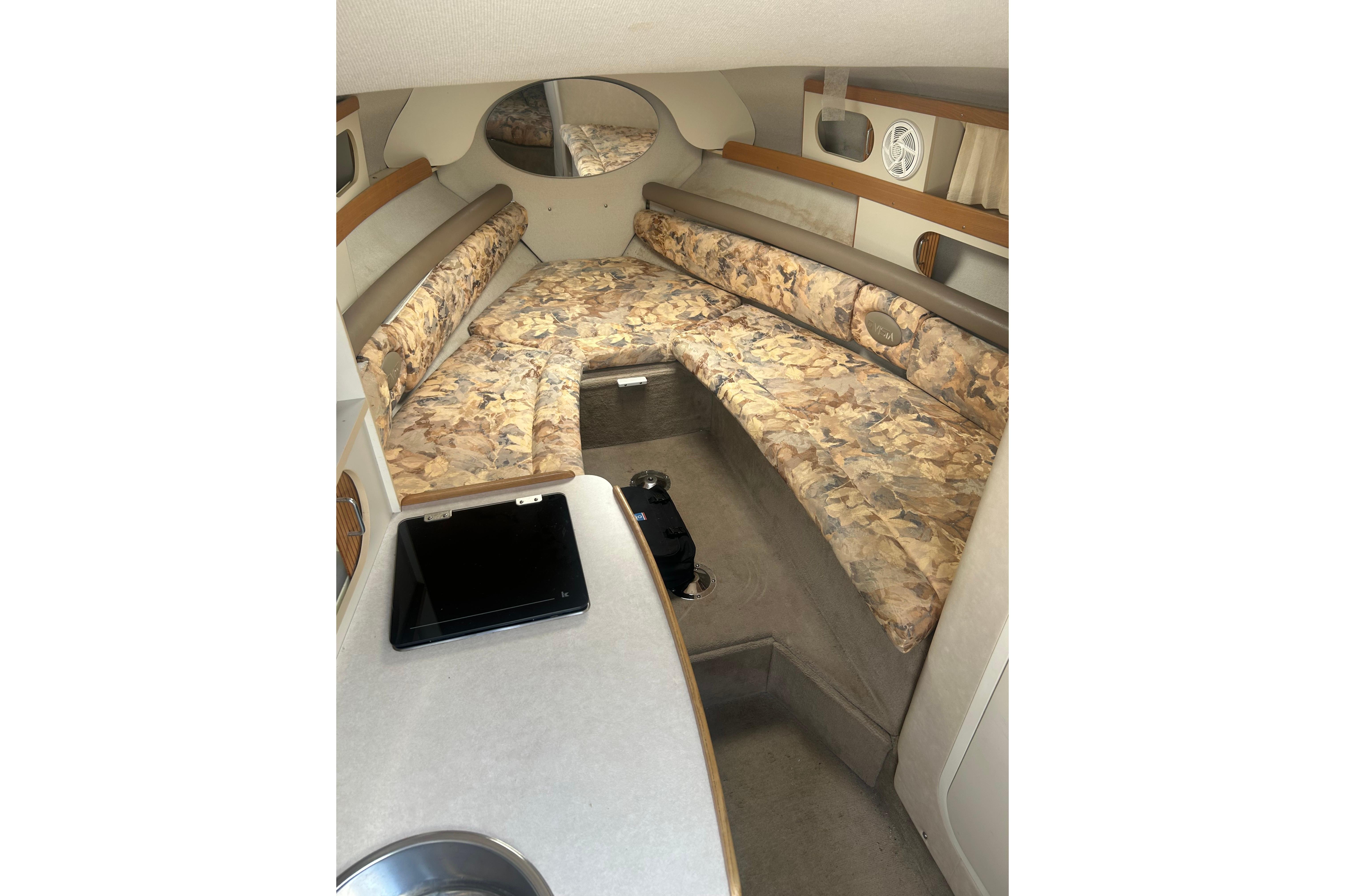 1998 Four Winns 258 Vista cabin interior with floral upholstery and compact kitchenette.