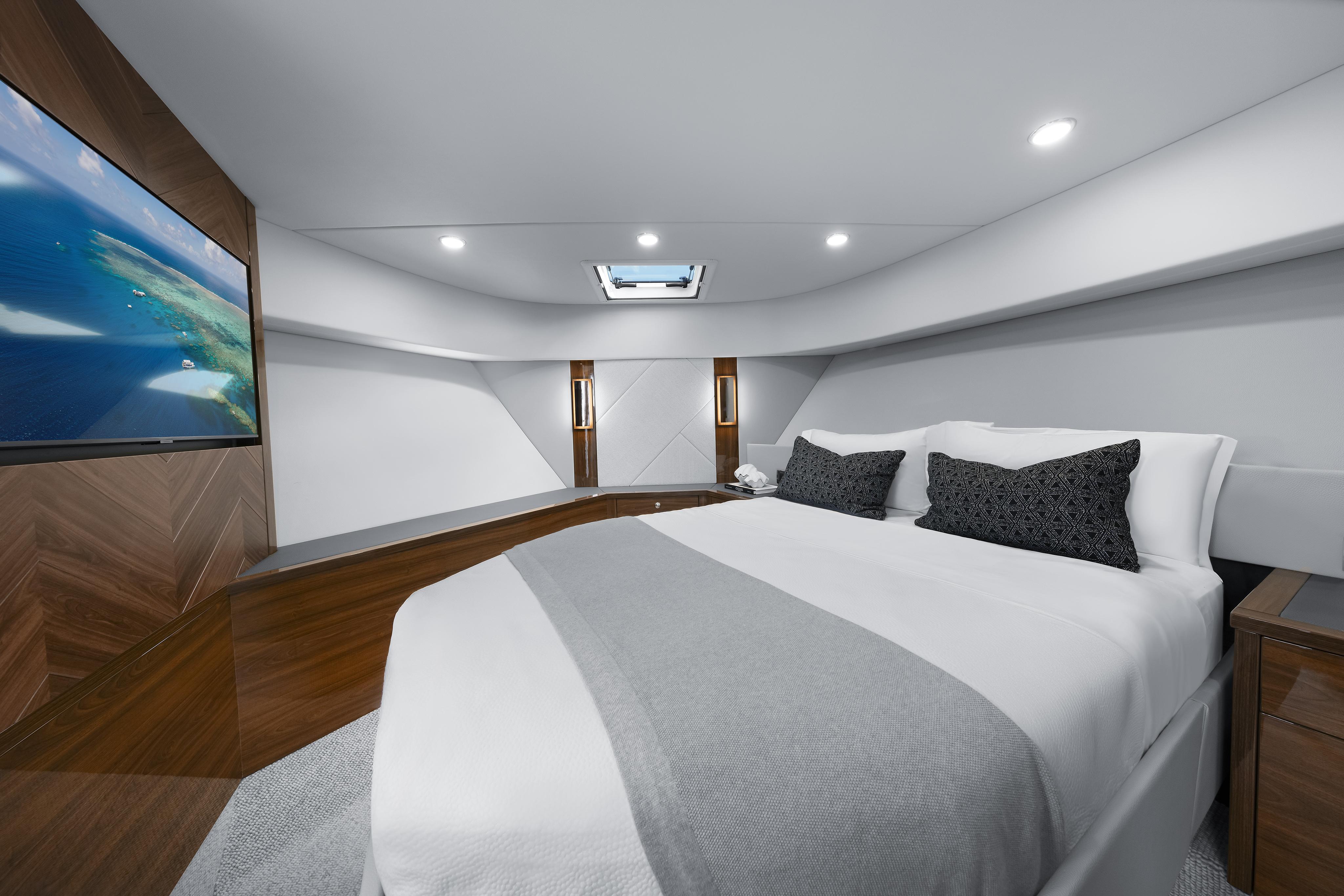 Luxurious bedroom interior of 2026 Maritimo M600 yacht with modern design and large screen TV.
