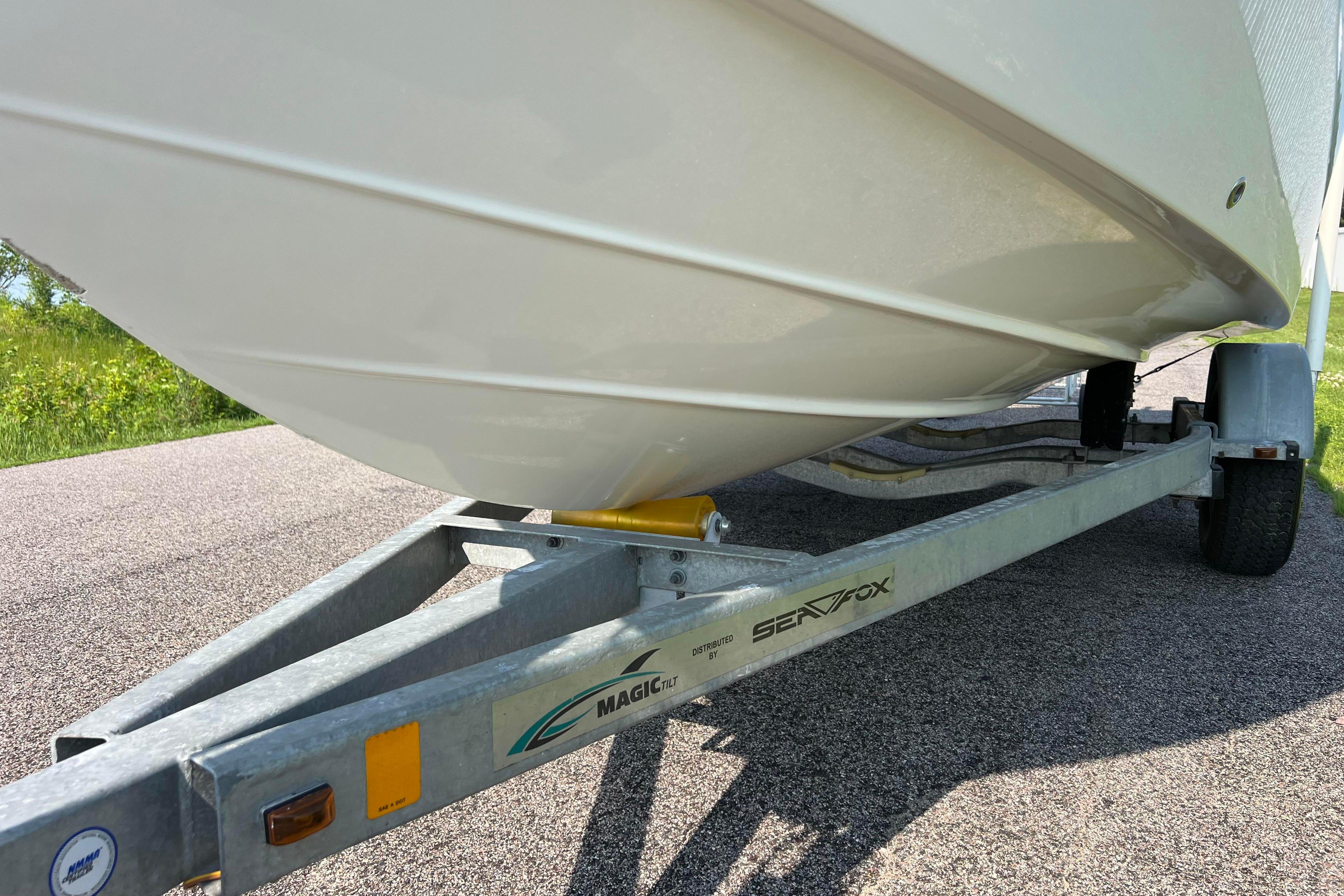 2012 Sea Fox 206 Center Console boat on trailer, parked on a paved road.