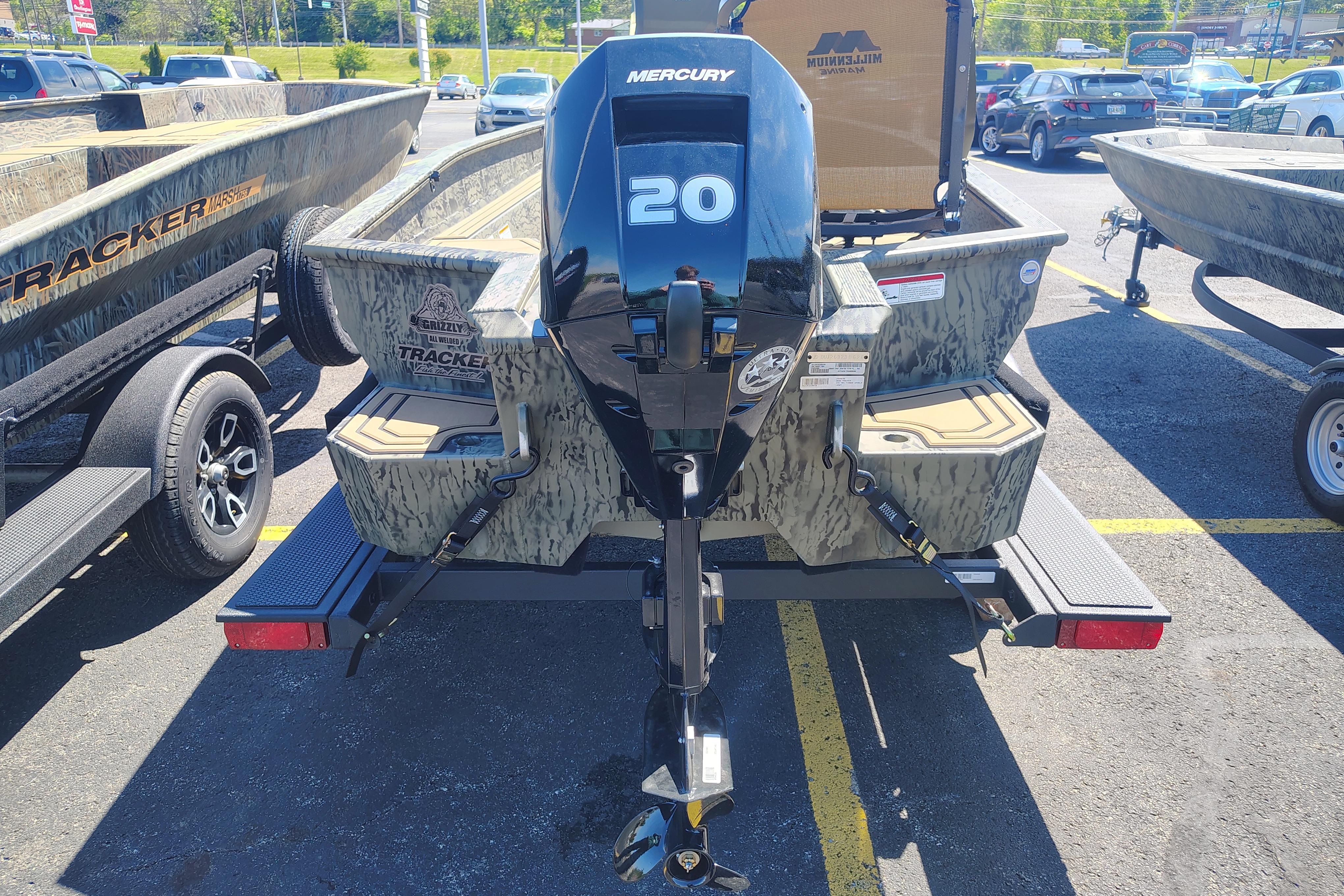 2026 Tracker Grizzly 1650 T Prairie Wings Edition boat with Mercury 20 engine in parking lot.