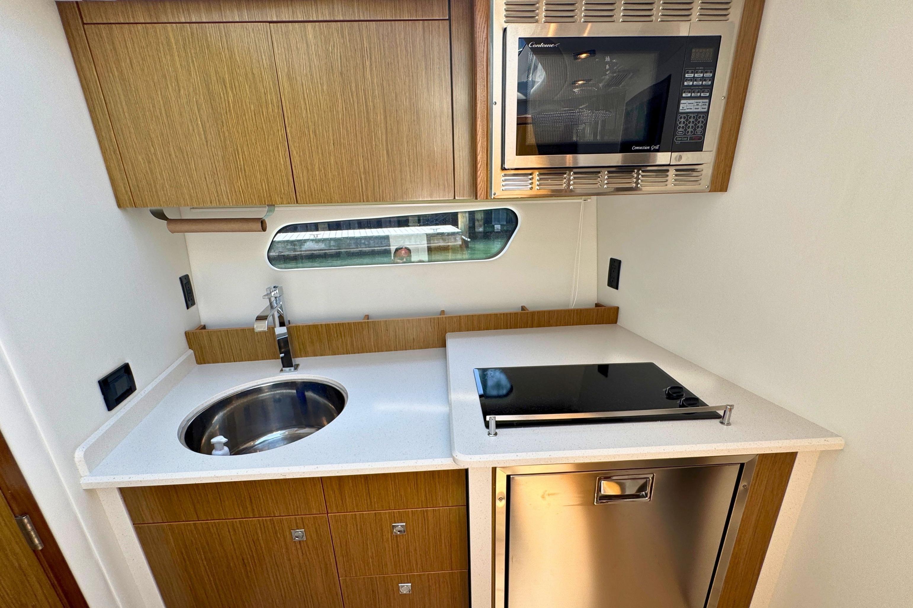2014 Cruisers Yachts 41 Cantius kitchen with sink, stove, and microwave.