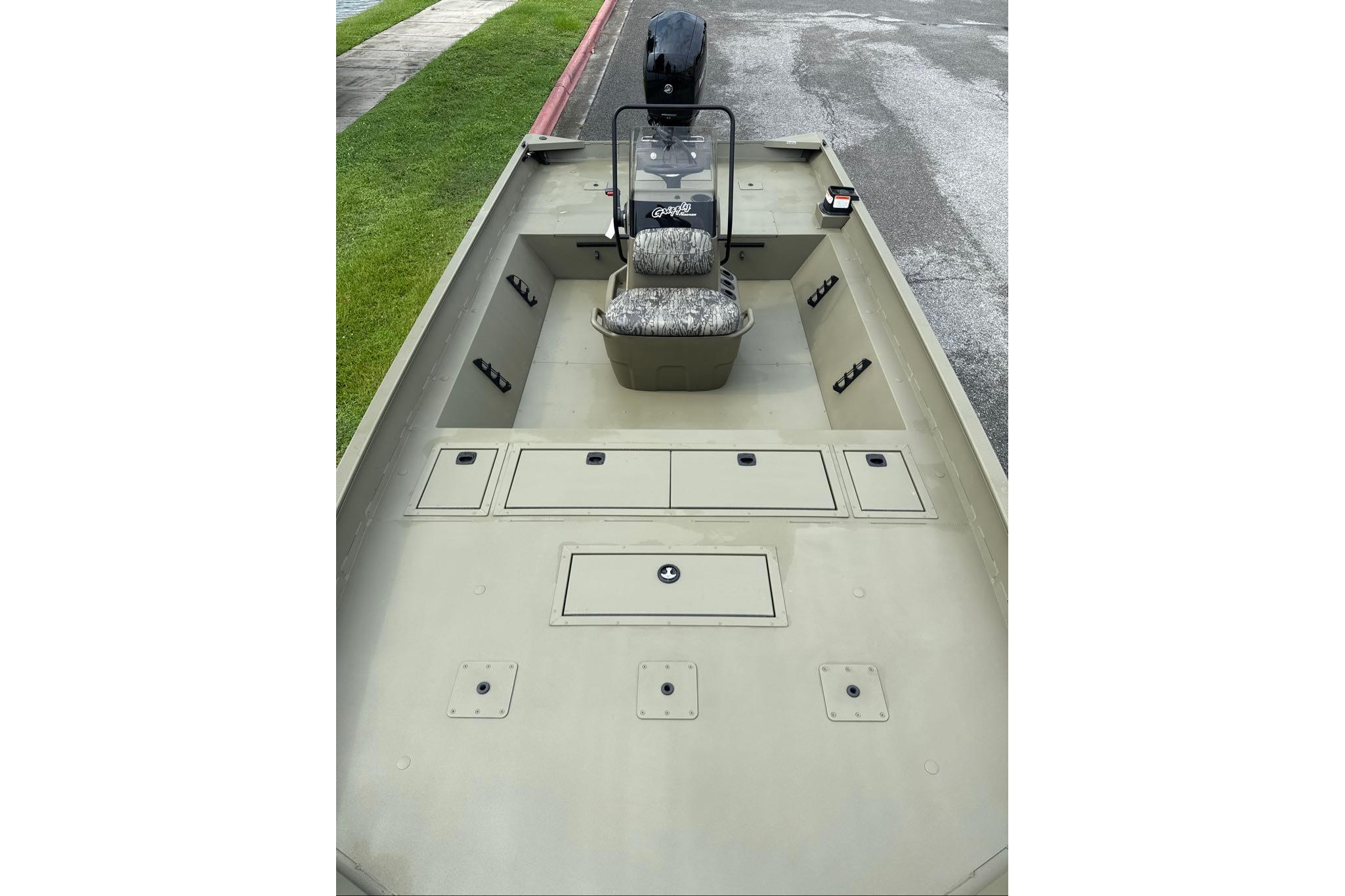 2026 Tracker Grizzly 2072 CC boat interior with camo seat and storage compartments.