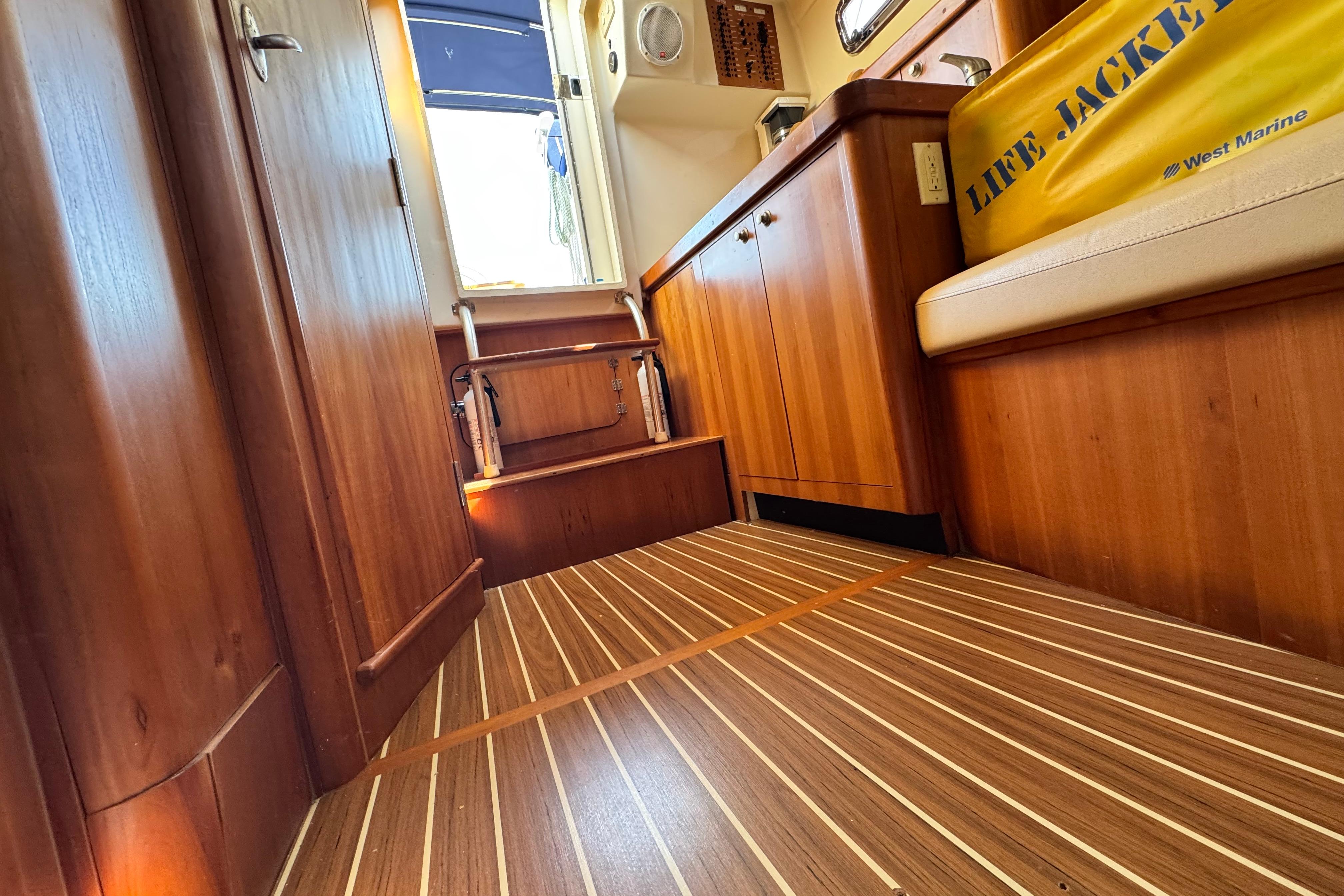 Interior of 2004 Mainship Pilot 30 Rum Runner with wood flooring and cabinetry.