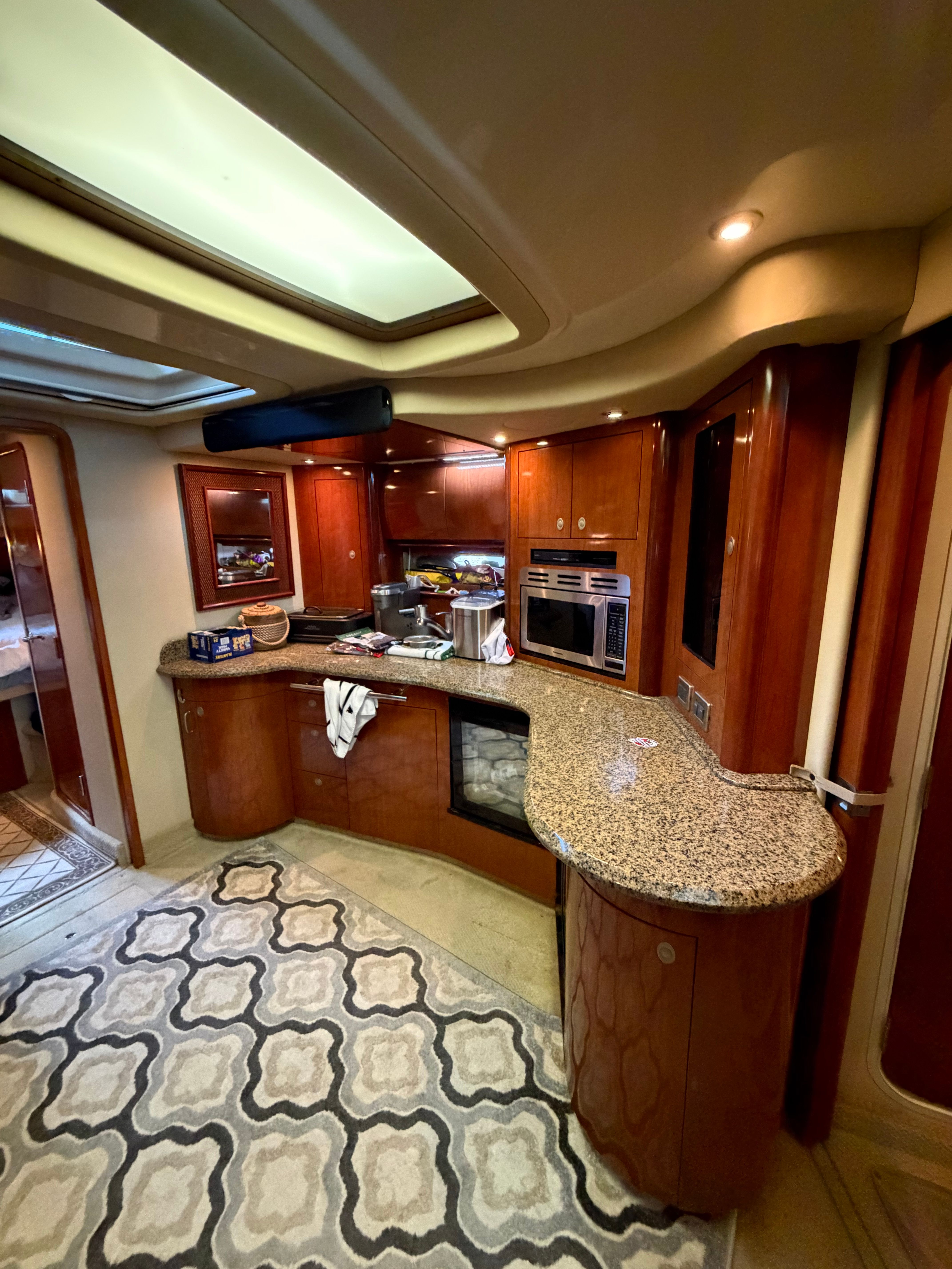 The interior of a 2005 Sea Ray 420DA features an elegant kitchen with wood cabinets and granite countertops.