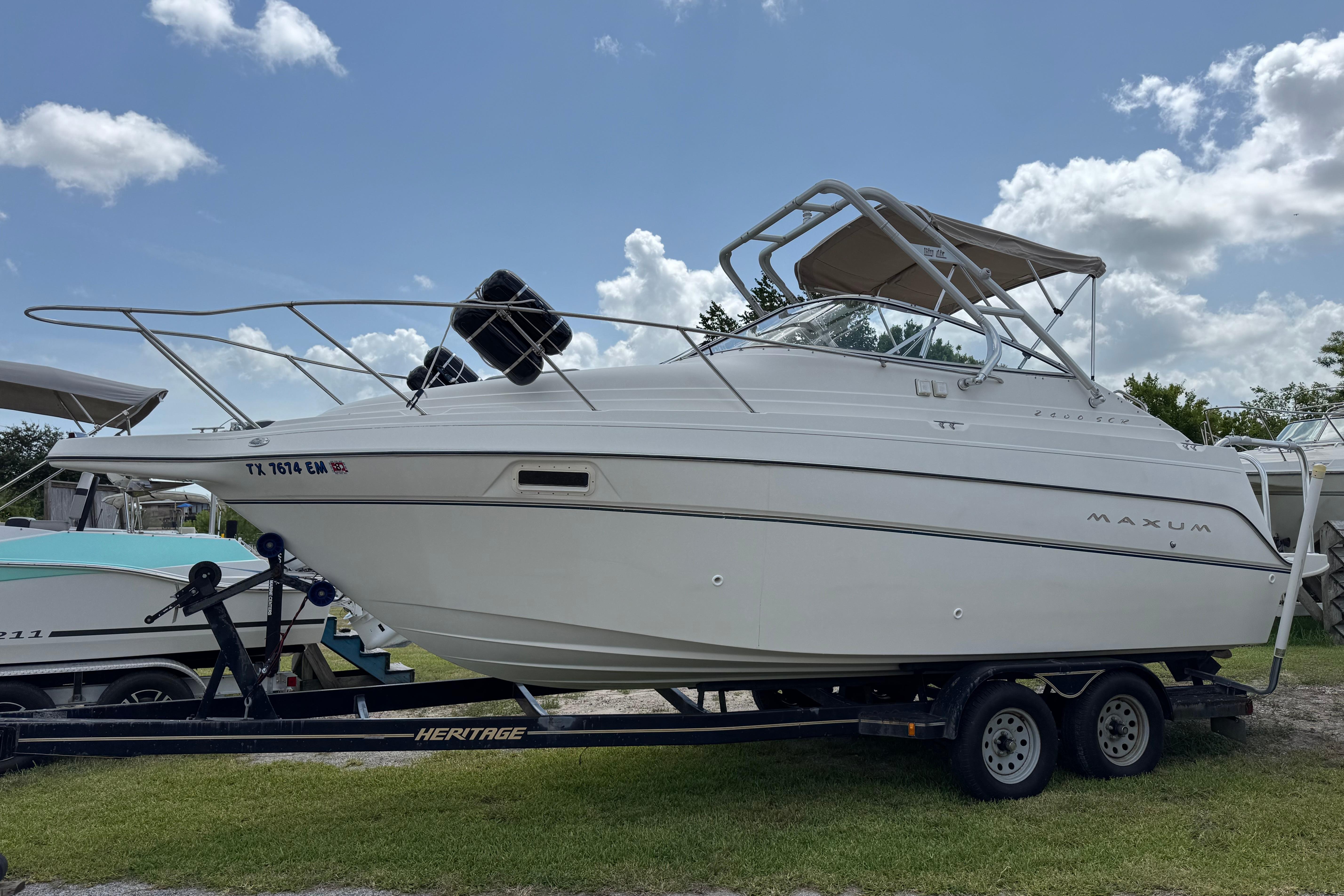 2000 Maxum 2400 SCR boat on trailer under clear sky.