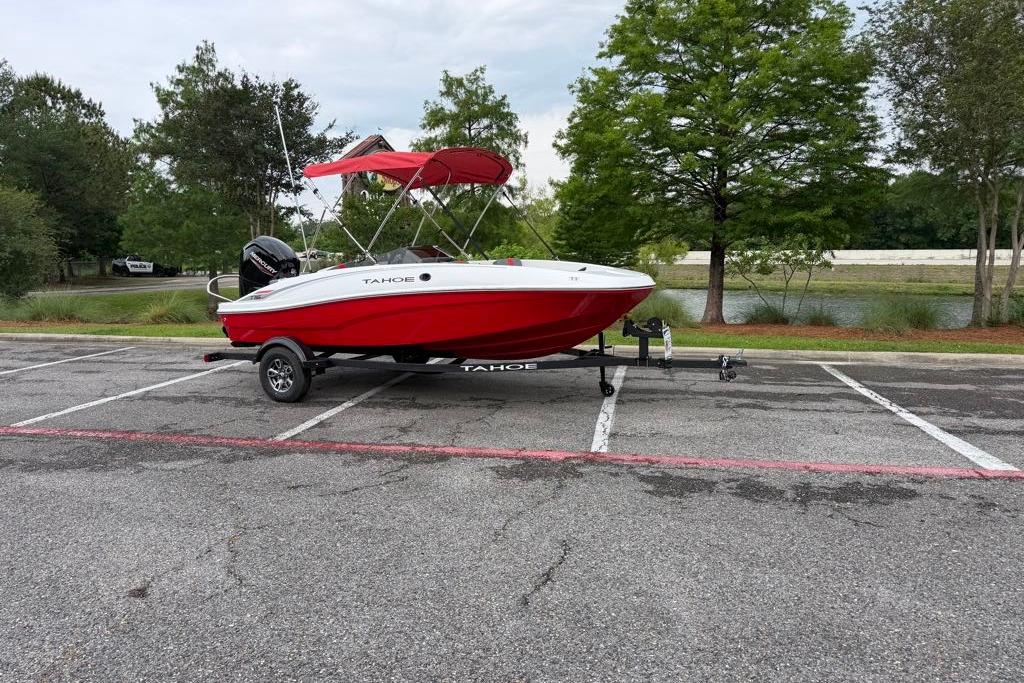 2026 Tahoe T16 boat with red canopy on trailer in parking lot.