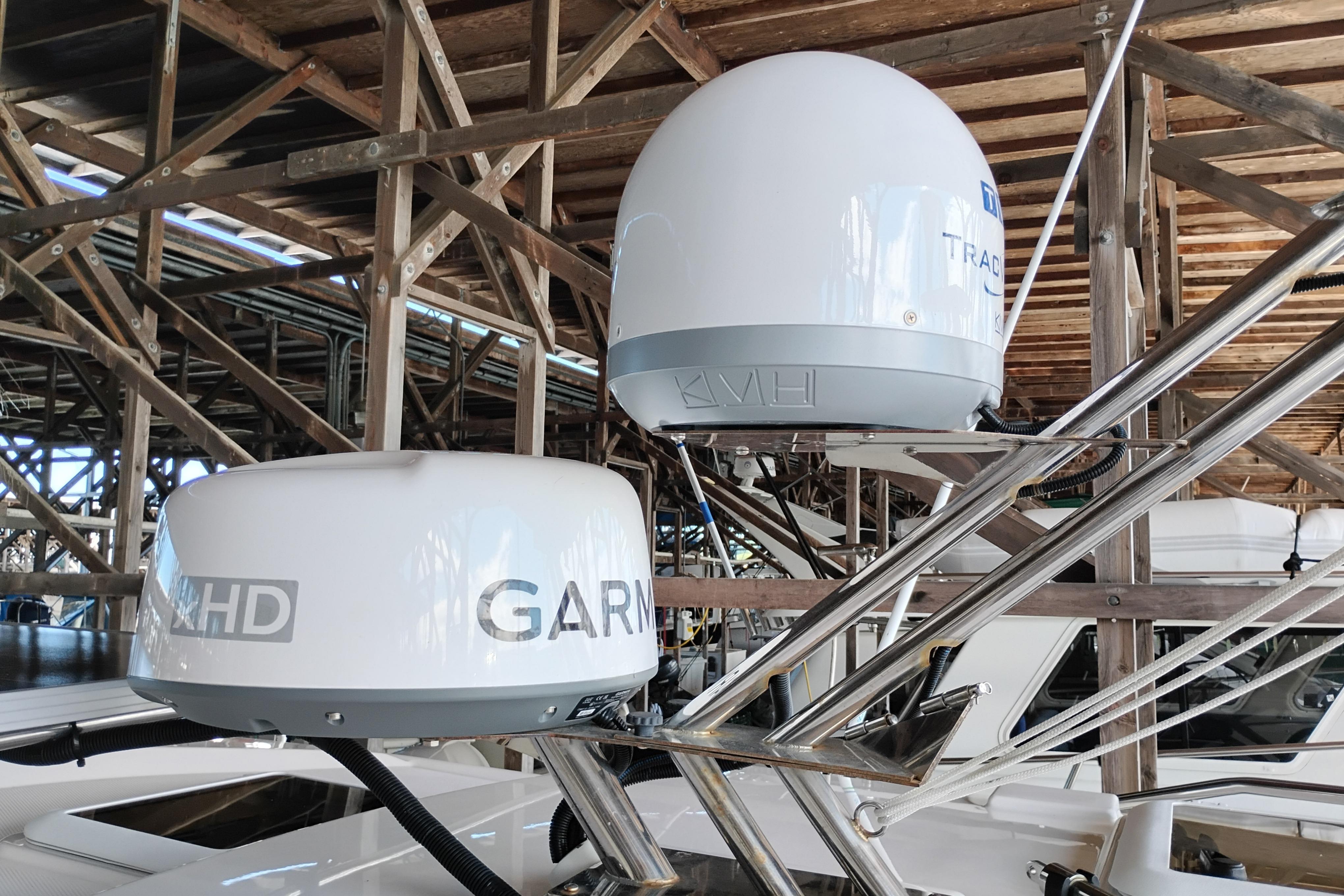 Satellite domes on a 2022 Cutwater C-32 Coupe boat in a wooden dock.
