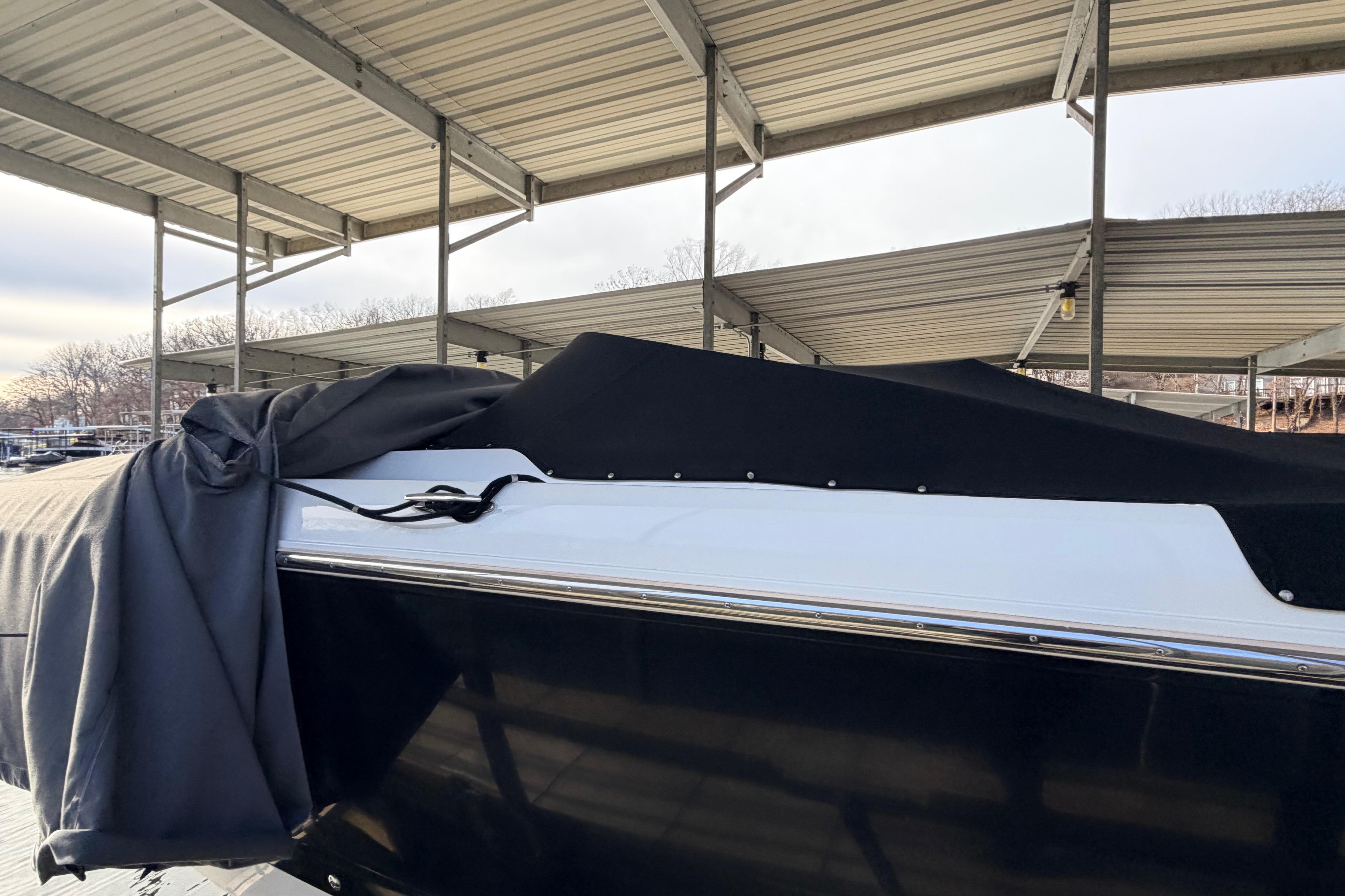 Covered 2004 Cobalt 343 boat under a metal canopy at a marina.