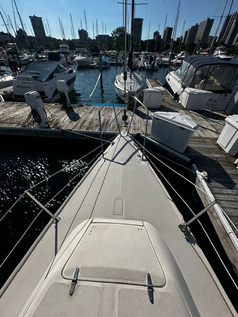 Bow of a sailboat in a marina with other boats in the background.