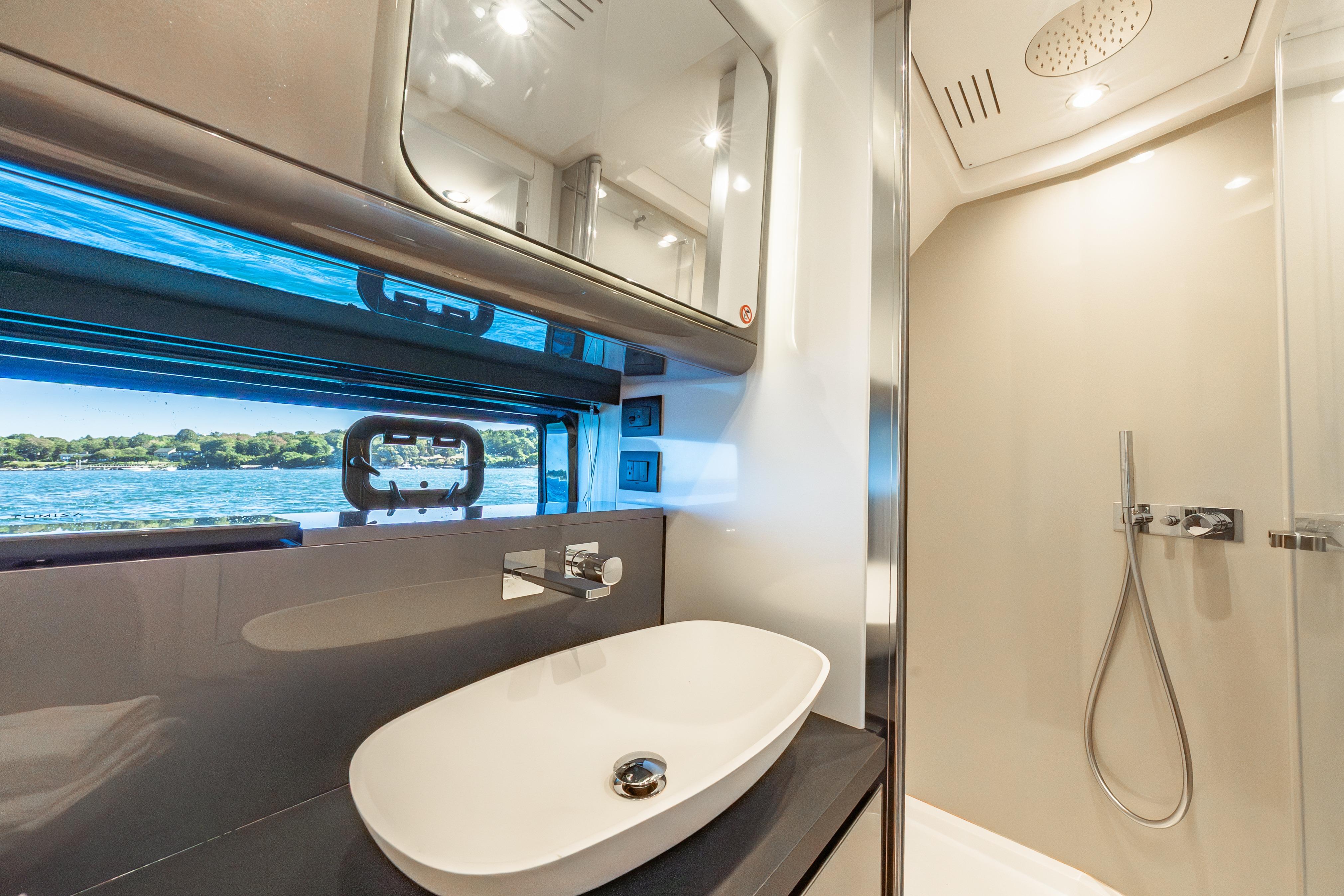 Luxurious bathroom interior of 2023 Azimut Verve 47 yacht with modern fixtures and scenic window view.
